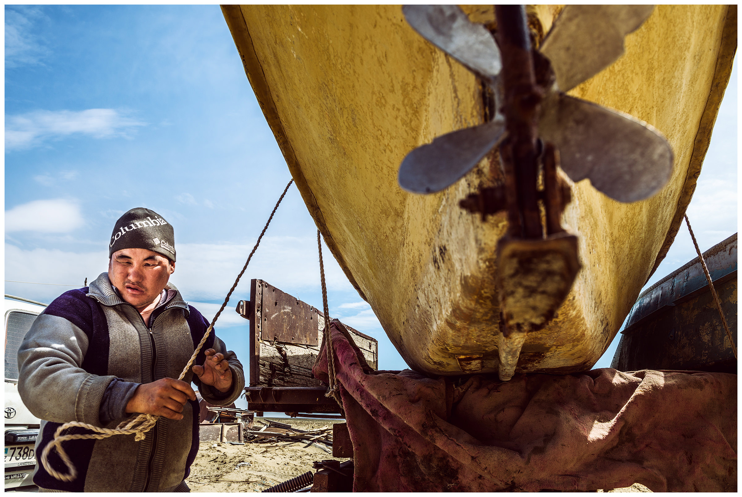 A fisherman attaches a fishing boat to a car trailer