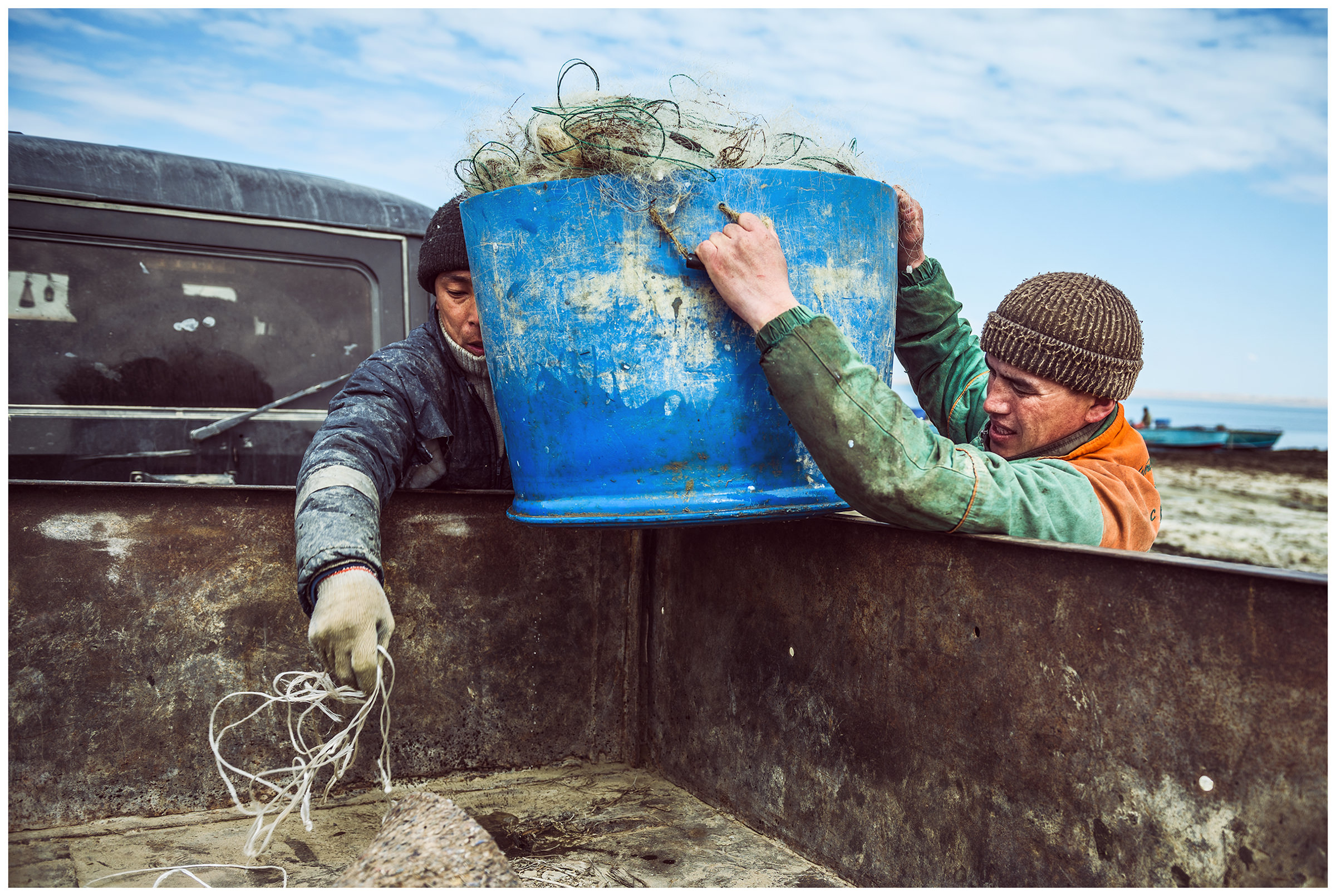 Fishermen load fishing nets into their cars