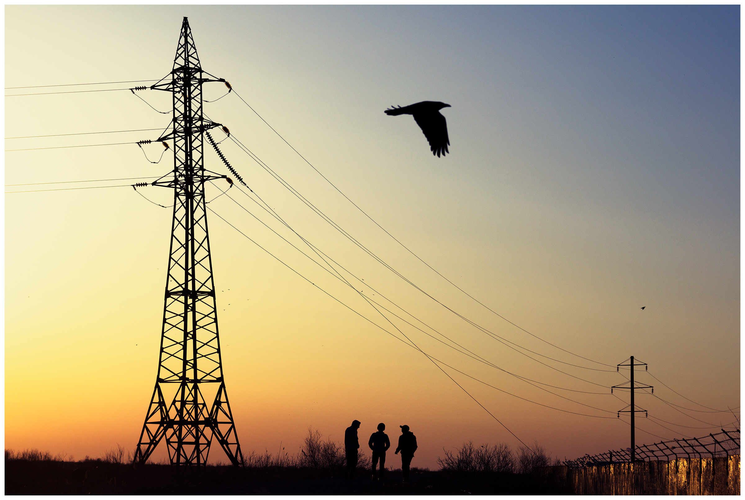 Three boys walk on the promenade of the river Syr Darya