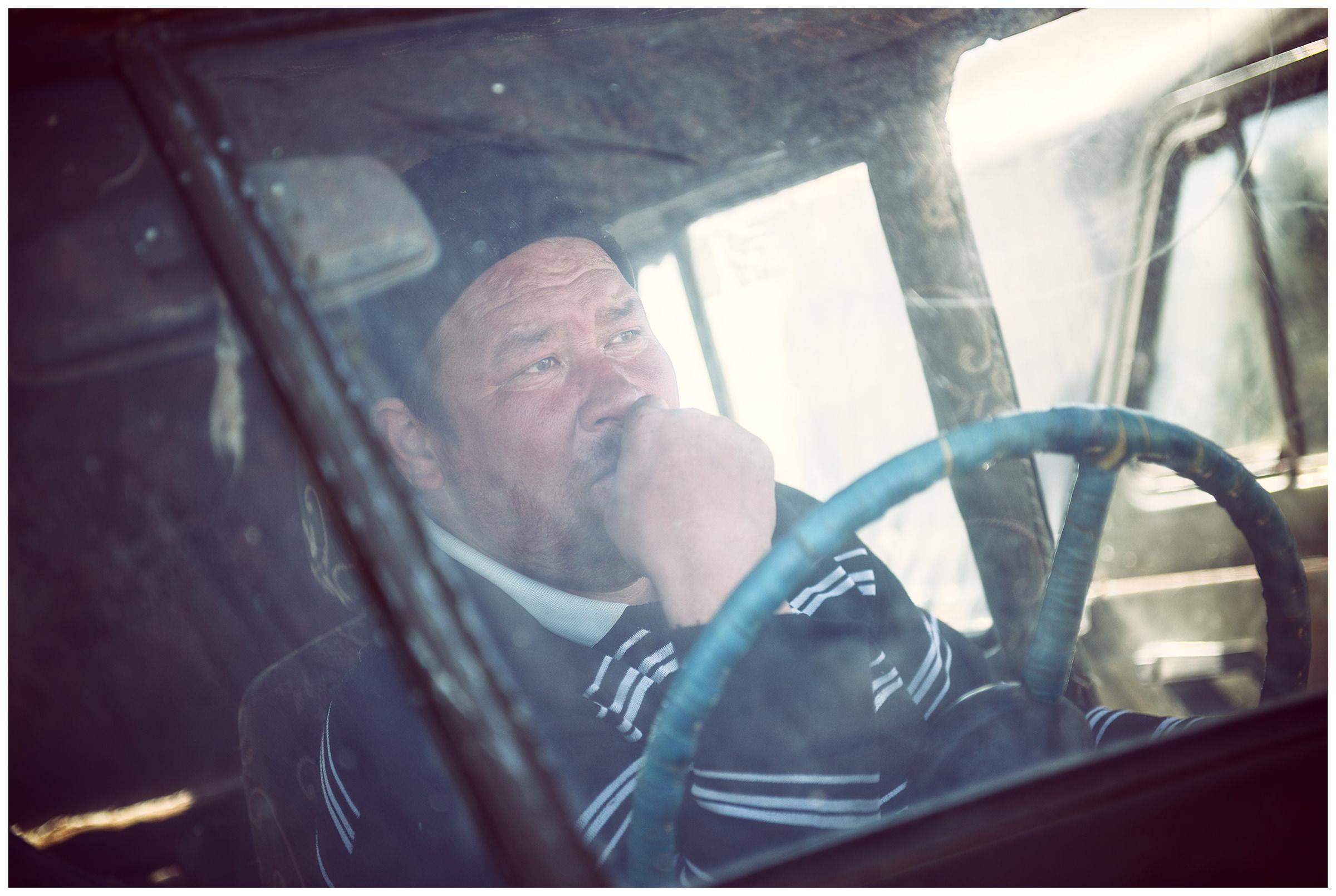 A fisherman recovers after work in his car