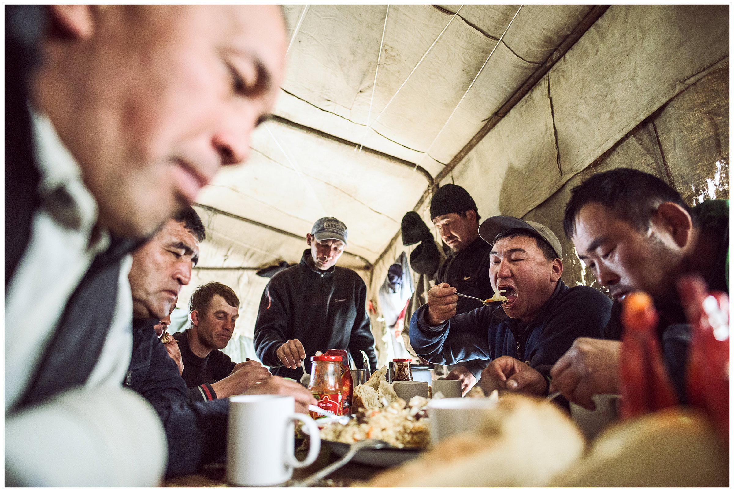 A fishing is eating at a table in their tent