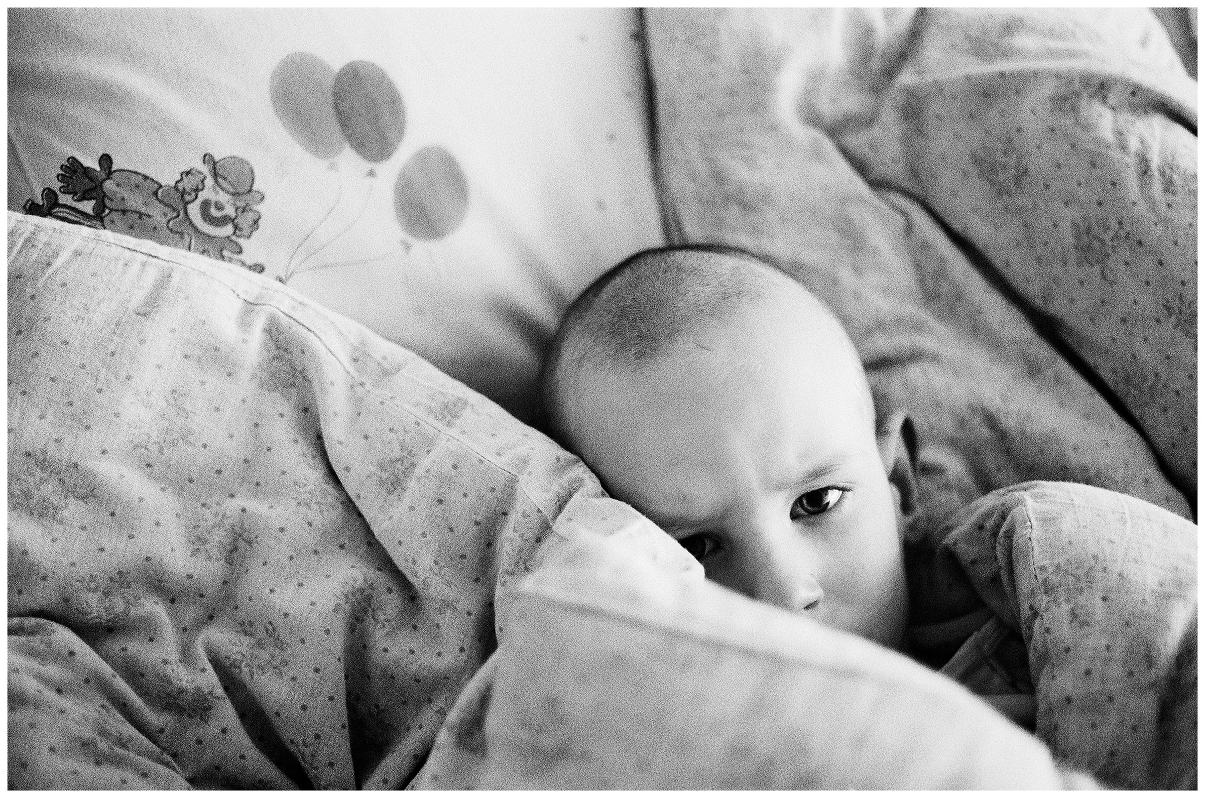 Minsk, Belarus. A boy is lying in his bed.