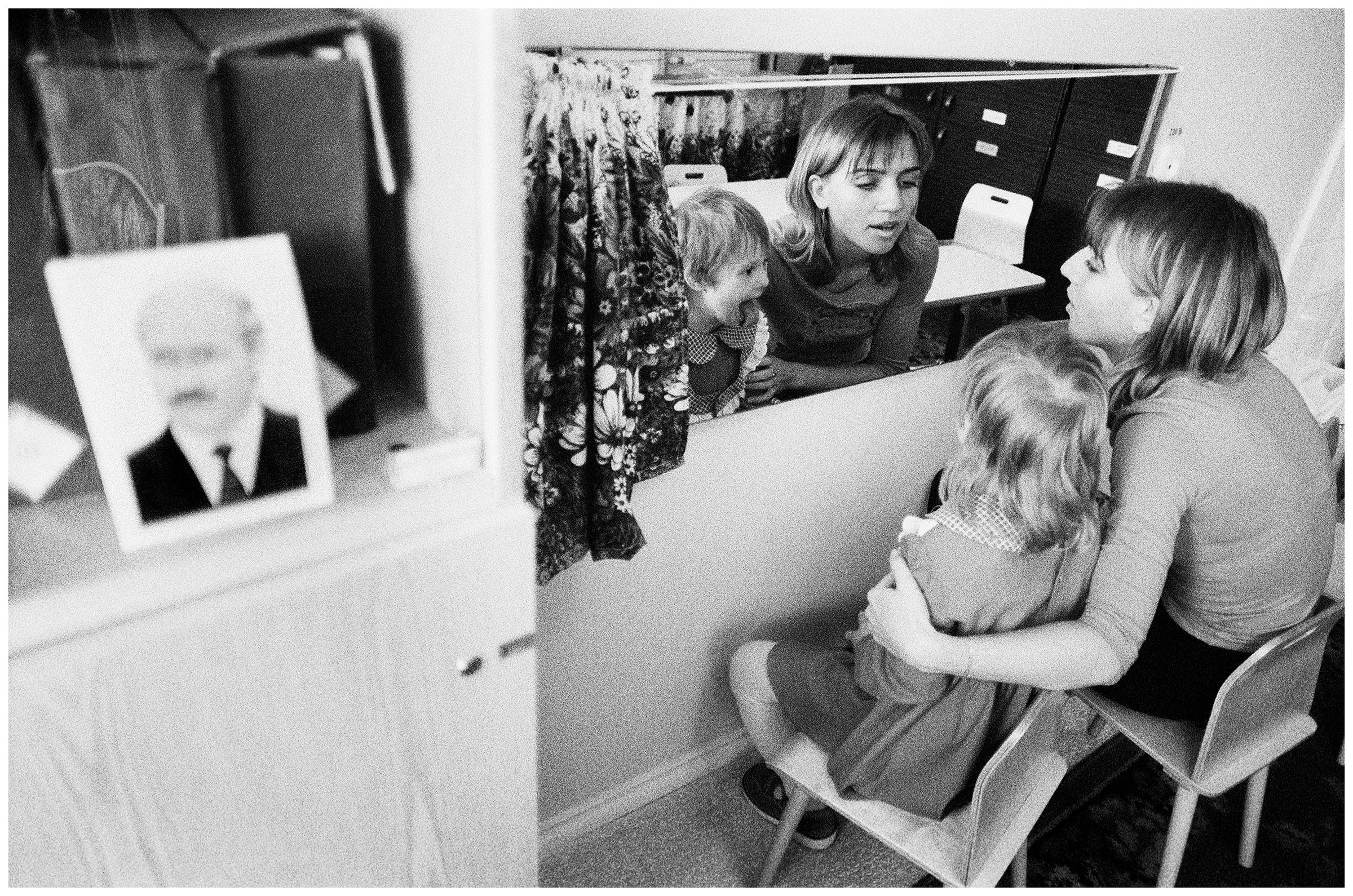 Minsk, Belarus. A logopaedin trains correct articulation with a psychophysically handicapped girl. On the left is an obligatory portrait of President Lukashenko.