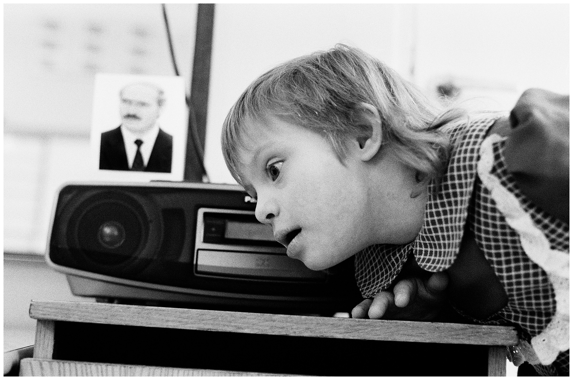 Minsk, Belarus. A girl with Down's syndrome is playing with a cassette recorder with an obligatory portrait of President Lukashenko.