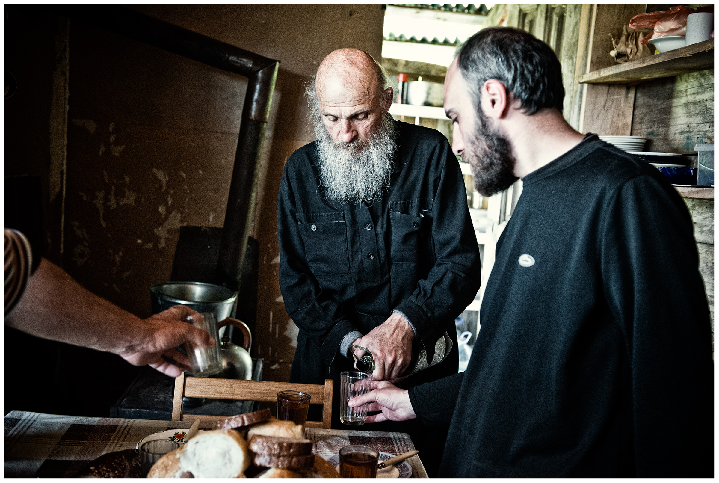 Imereti, Georgia. The Georgian monk Maxime Kavtaradze drinks wine with his friends in his house on a rock.