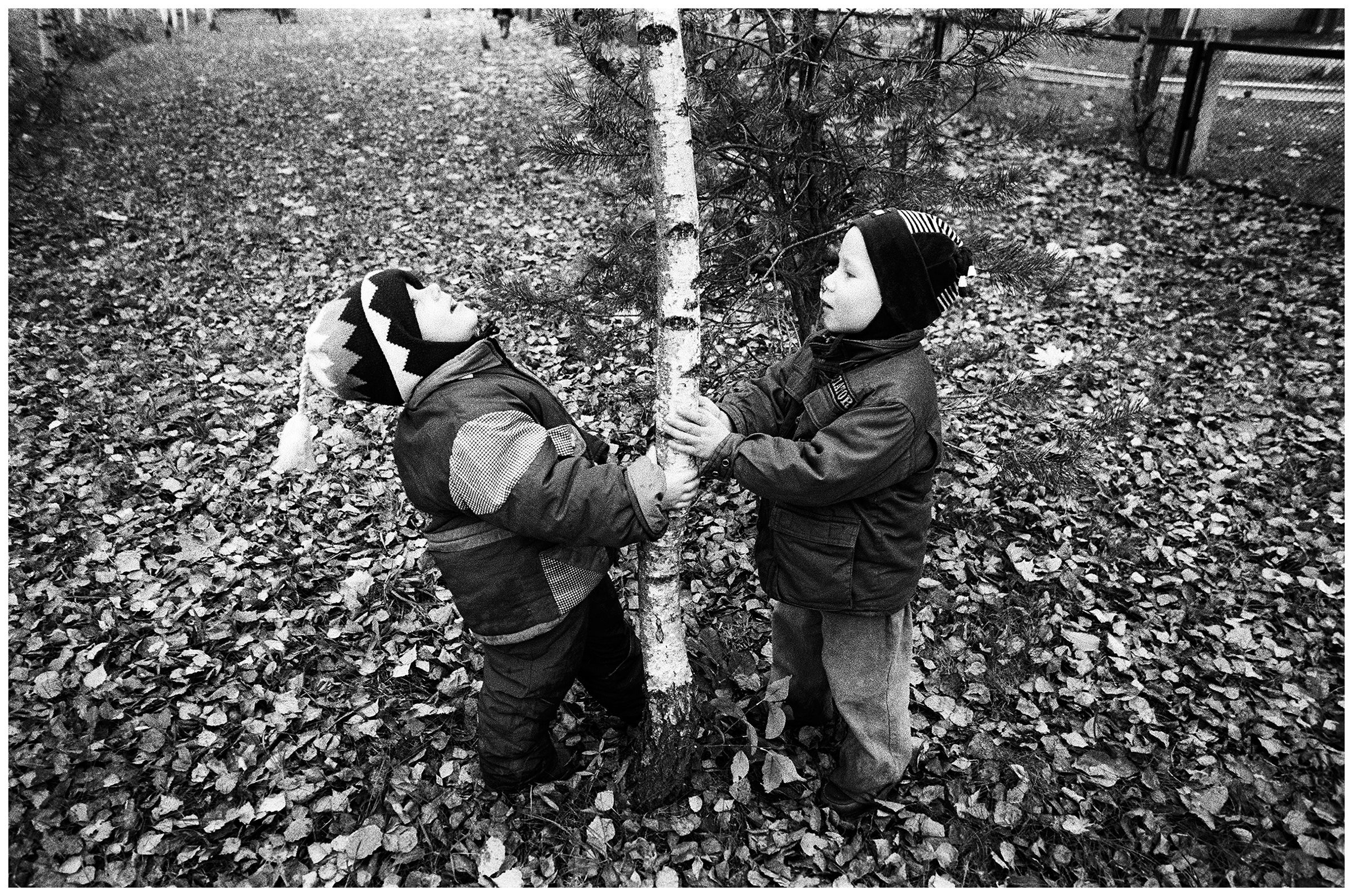 Minsk, Belarus. Two children play with a birch tree in the courtyard of a children's home.