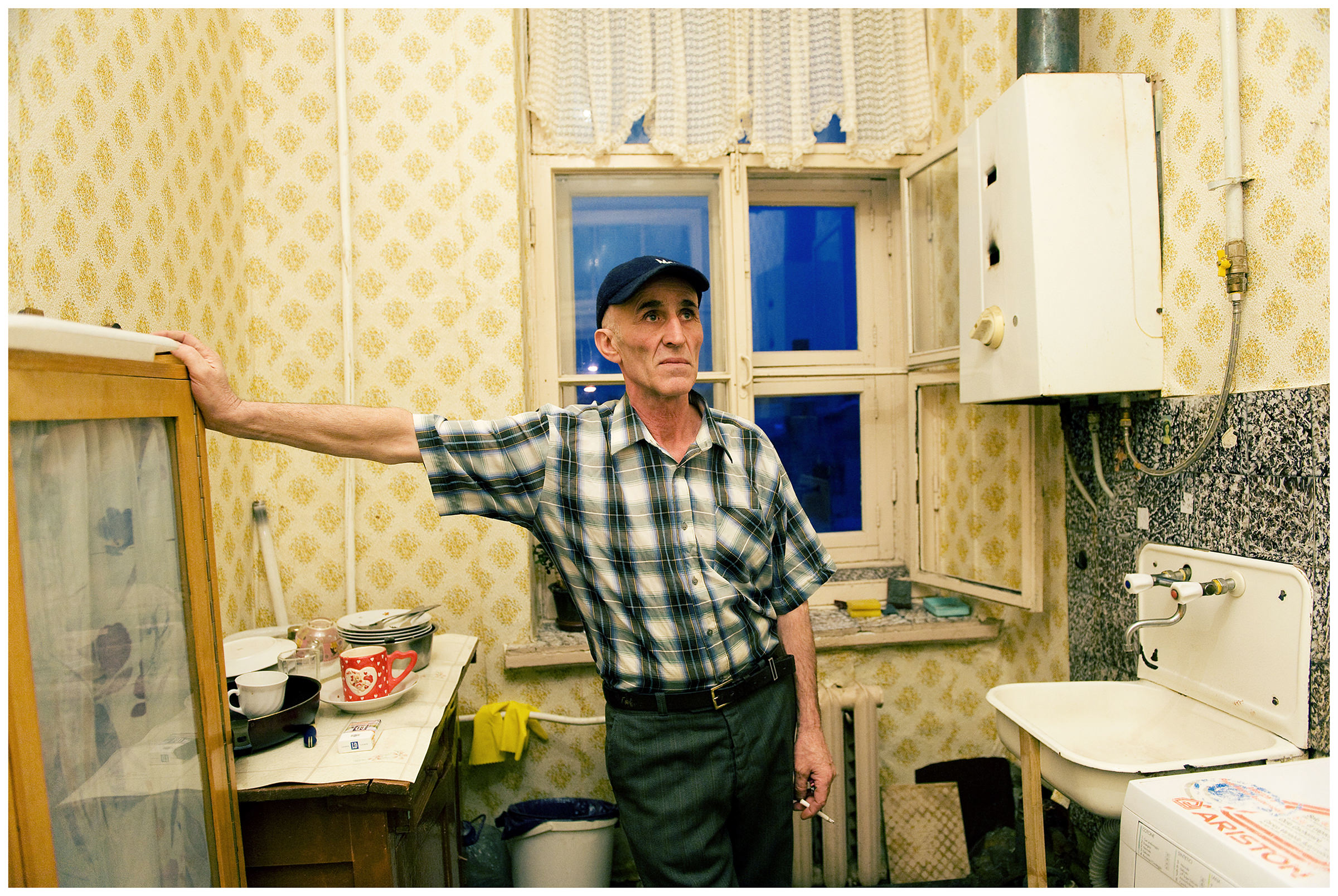 Saint Petersburg, Russia. A Georgian guest worker smokes in the kitchen of a rented apartment.