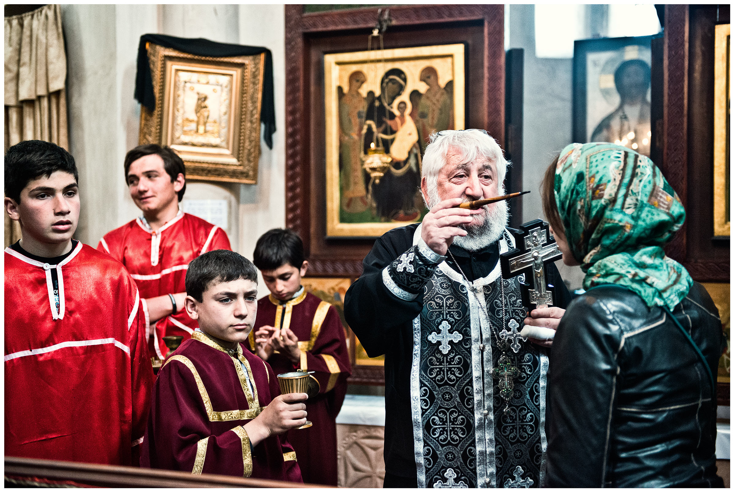 Imereti, Georgia. Believers and a priest are standing in a monastery.