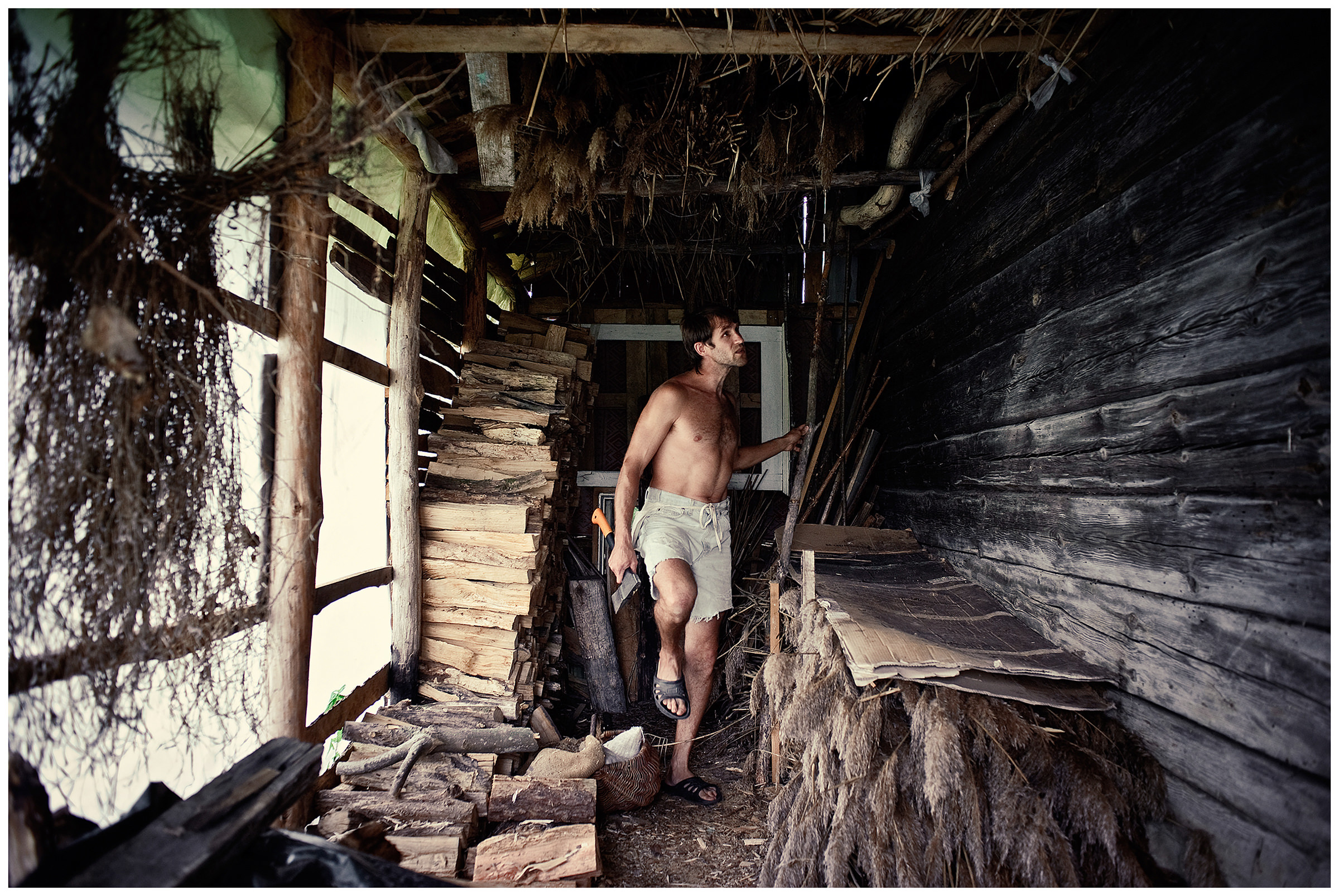 Belarus, village of Chereshlya. A man with an axe walks through a barn.