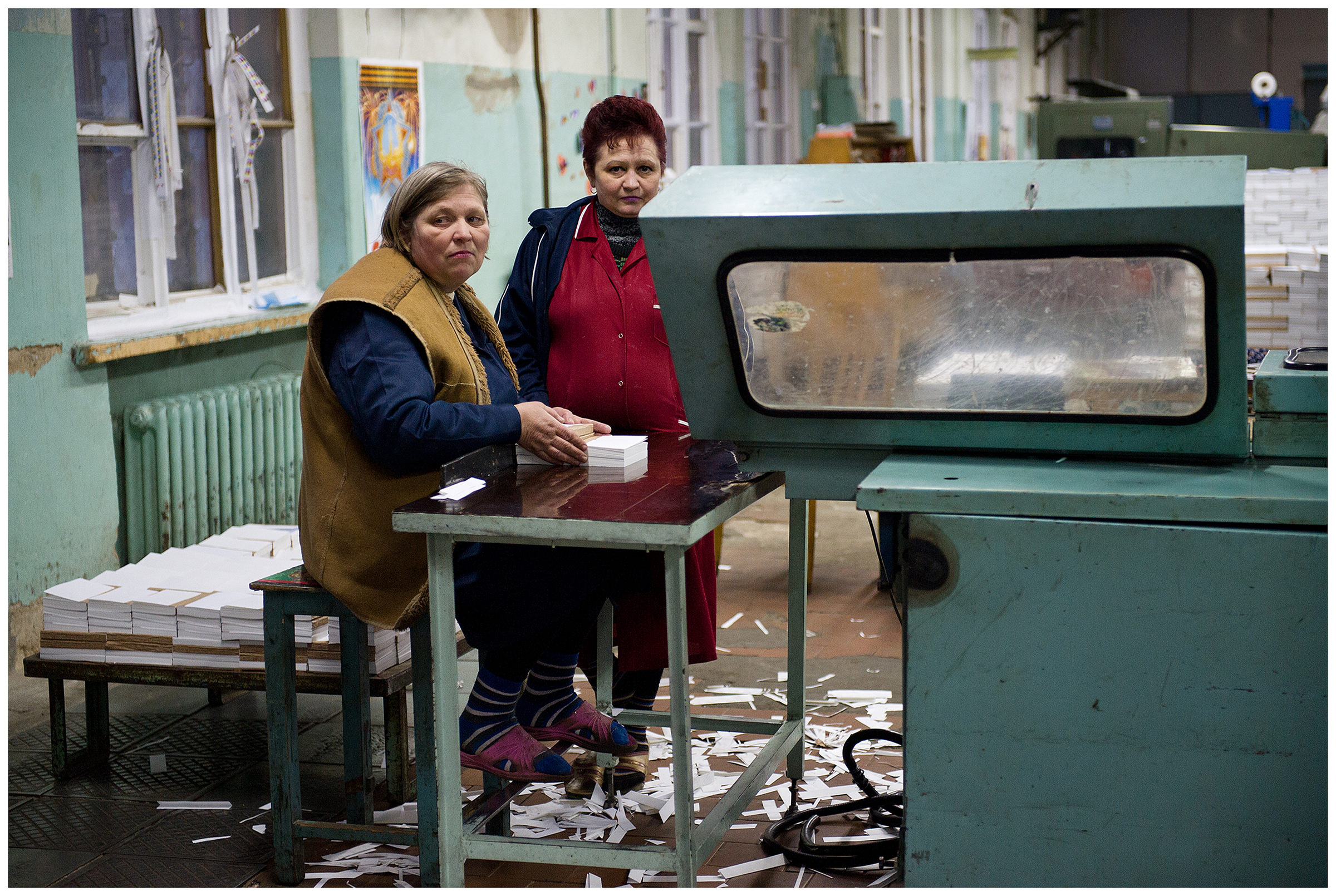 Minsk, Belarus, the publishing house "Pechatny Combinat". Two workers cut and sort the print production.