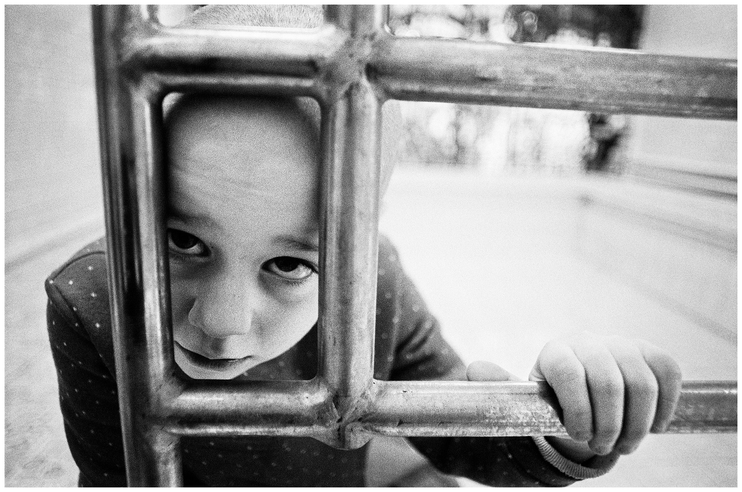 Minsk, Belarus. A girl is sitting at the edge of a swimming pool. The swimming pool has no water because the water in this district does not meet medical standards.