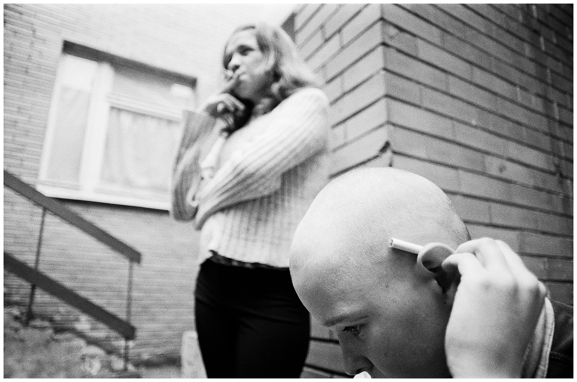 Minsk, Belarus. A girl and a boy smoke secretly in the backyard of a children's home.