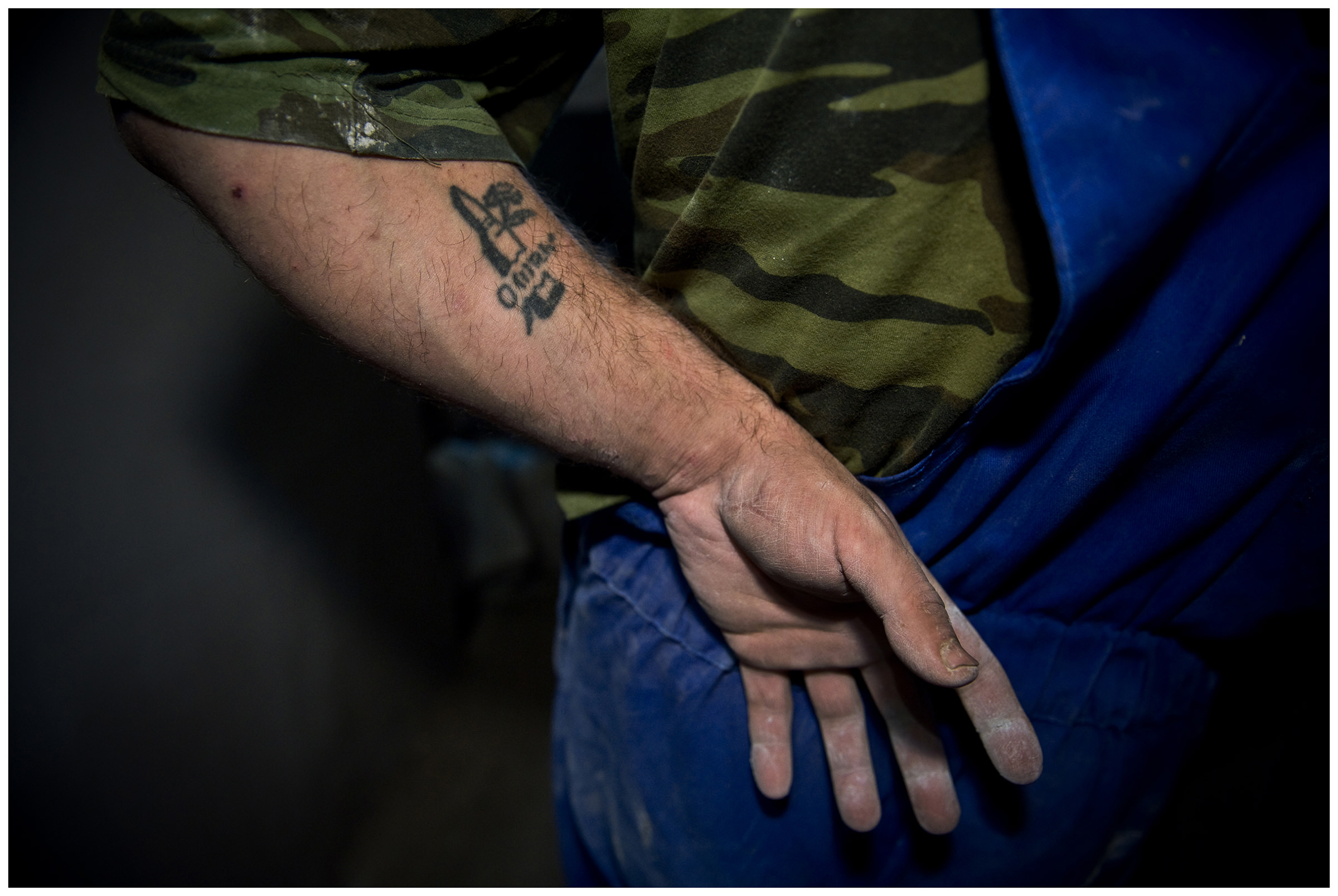 Saint Petersburg, Russia. A tattoo on the arm of an Uzbek guest worker shows a flower growing through a cartridge and his blood type.