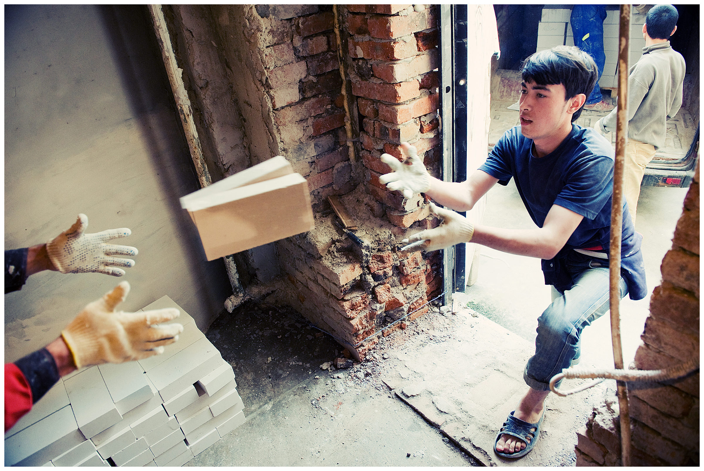 Saint Petersburg, Russia. An Uzbek guest worker throws bricks at a construction site.
