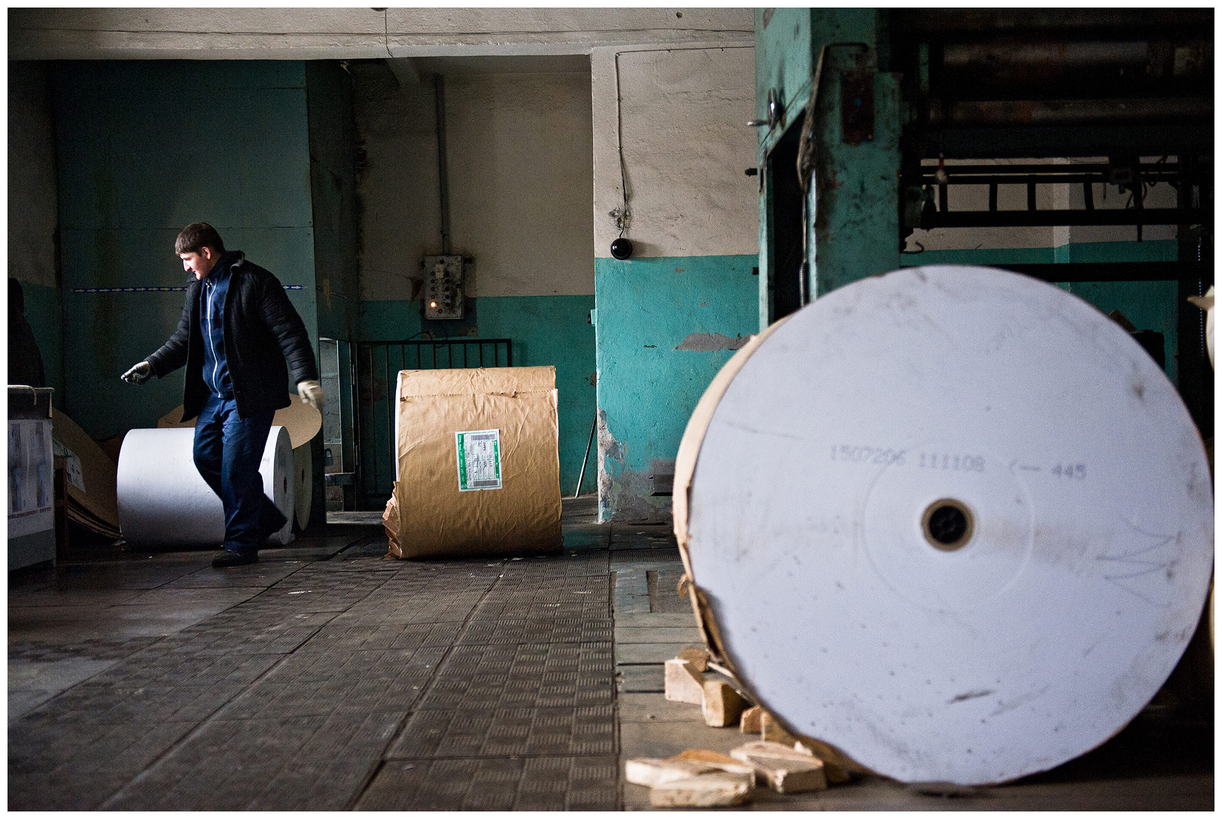 Minsk, Belarus, the publishing house "Pechatny Combinat". A warehouse worker sorts paper rolls.