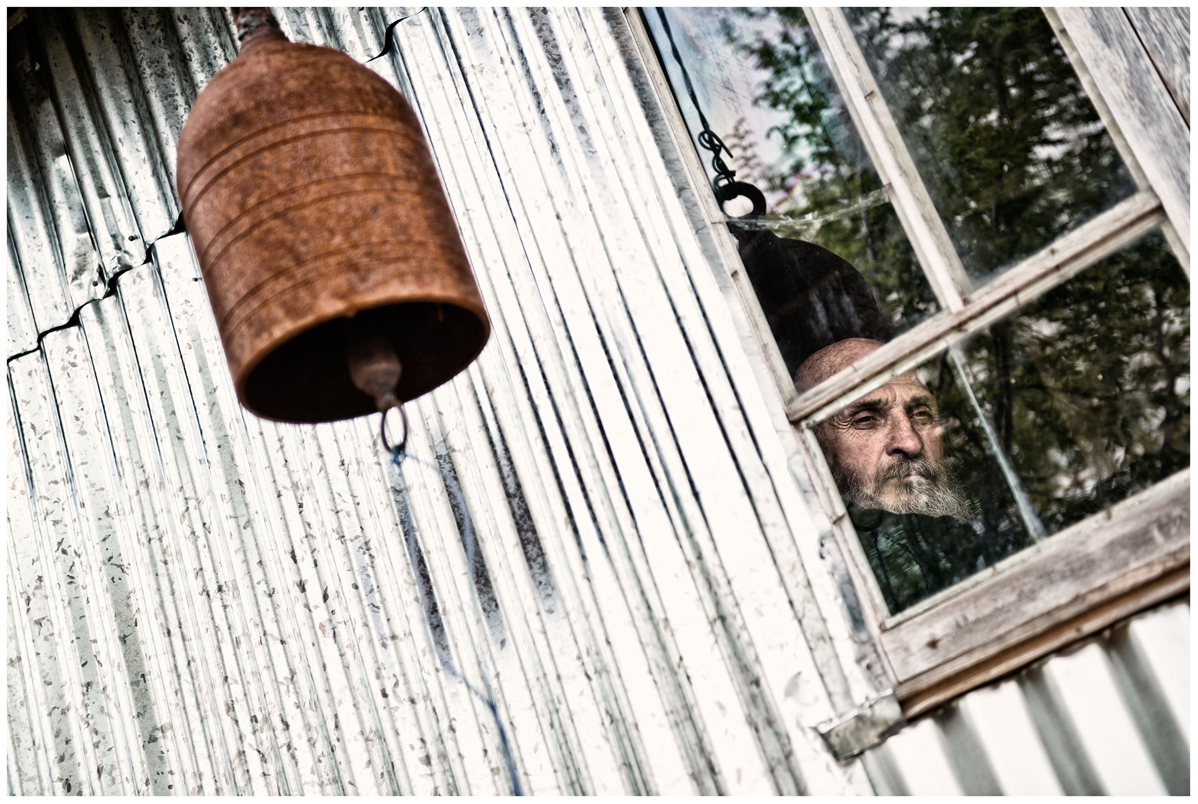 Imereti, Georgia. The Georgian monk Maxime Kavtaradze sits in front of a window in his house on a rock.