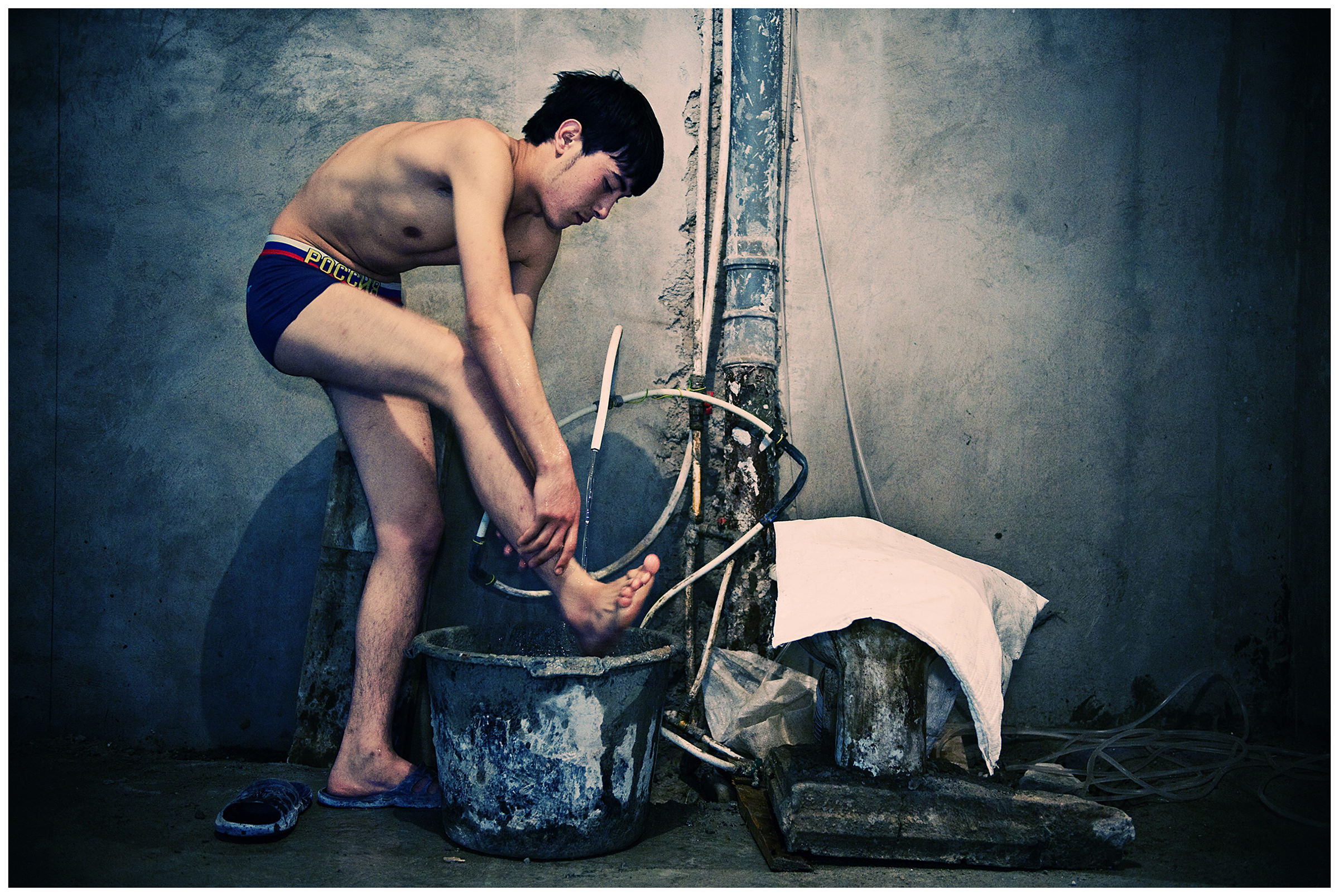 Saint Petersburg, Russia. An Uzbek guest worker is washing up at a construction site.
