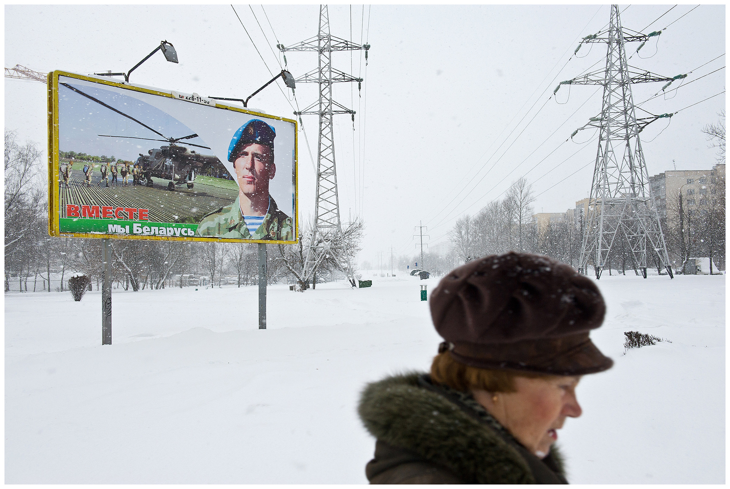 Minsk, Belarus, the publishing house "Pechatny Combinat". A passer-by passes a propaganda poster.