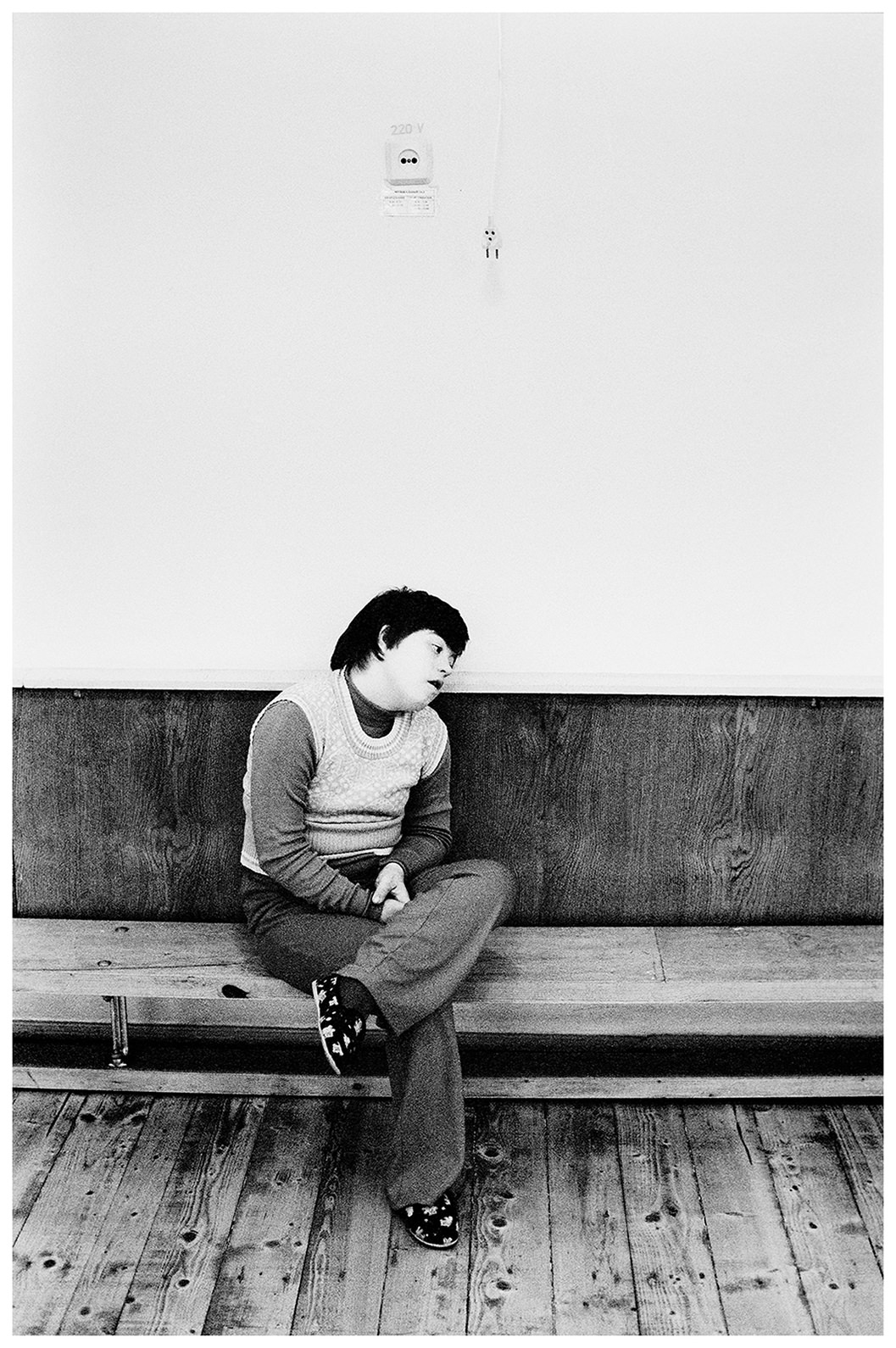 Minsk, Belarus. A boy with Down syndrome sits on a bench in the game room.