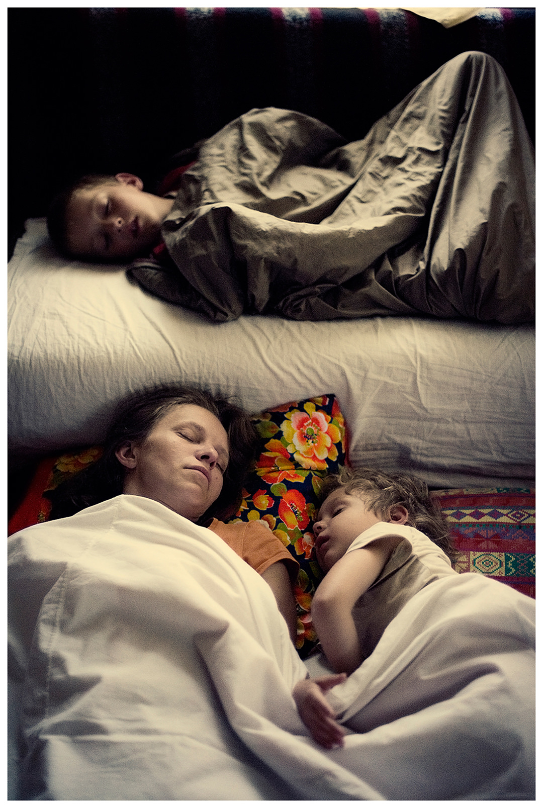 Belarus, village of Chereshlya. A woman sleeps with her children on the floor.
