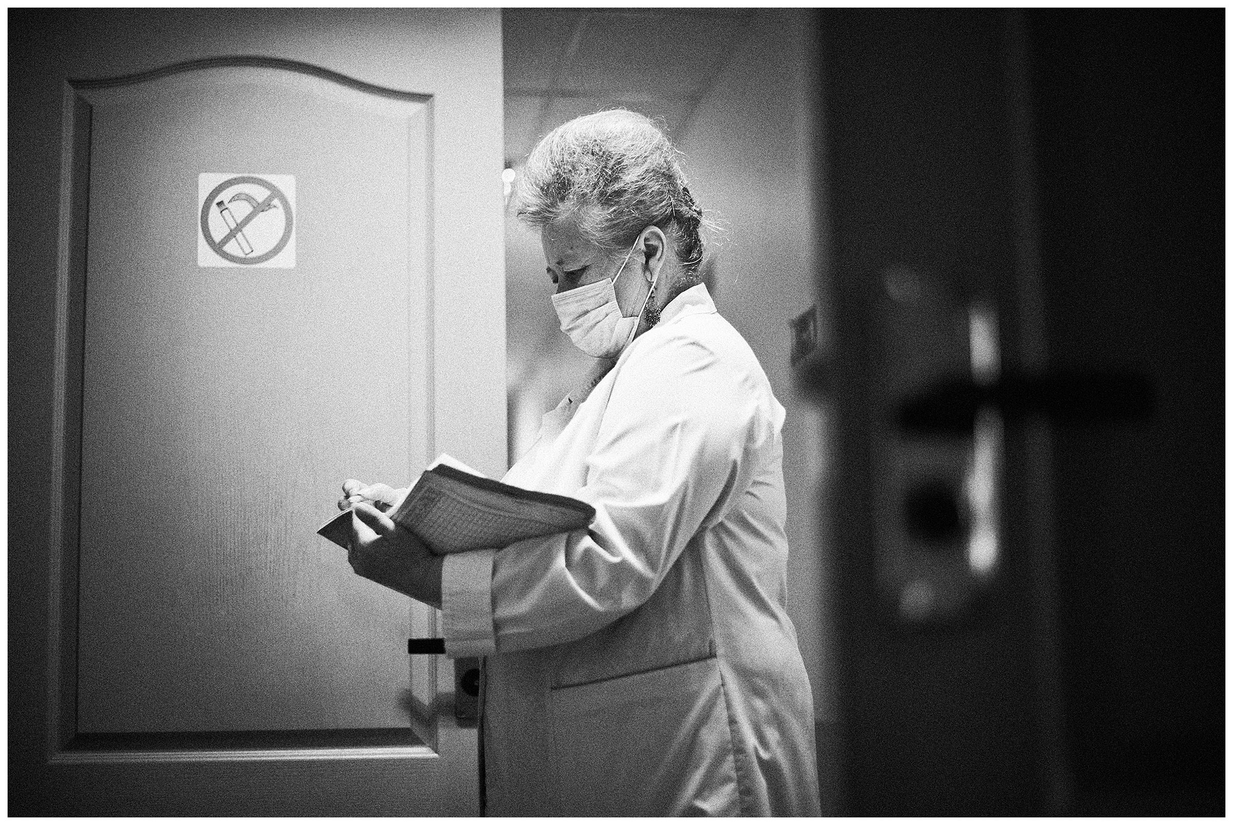 Minsk Hospice, Minsk, Belarus. A nurse notes how much bed linen was used.