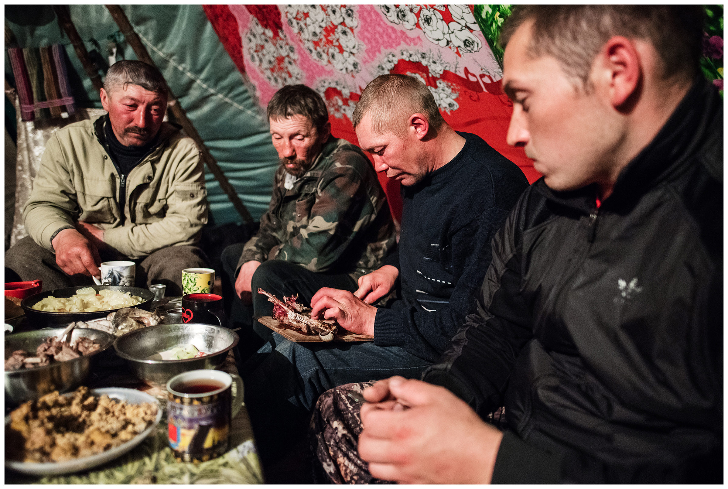 Nenets Autonomous Okrug, Komi Republic, Russia. Reindeer herders eat reindeer meat in their tent.