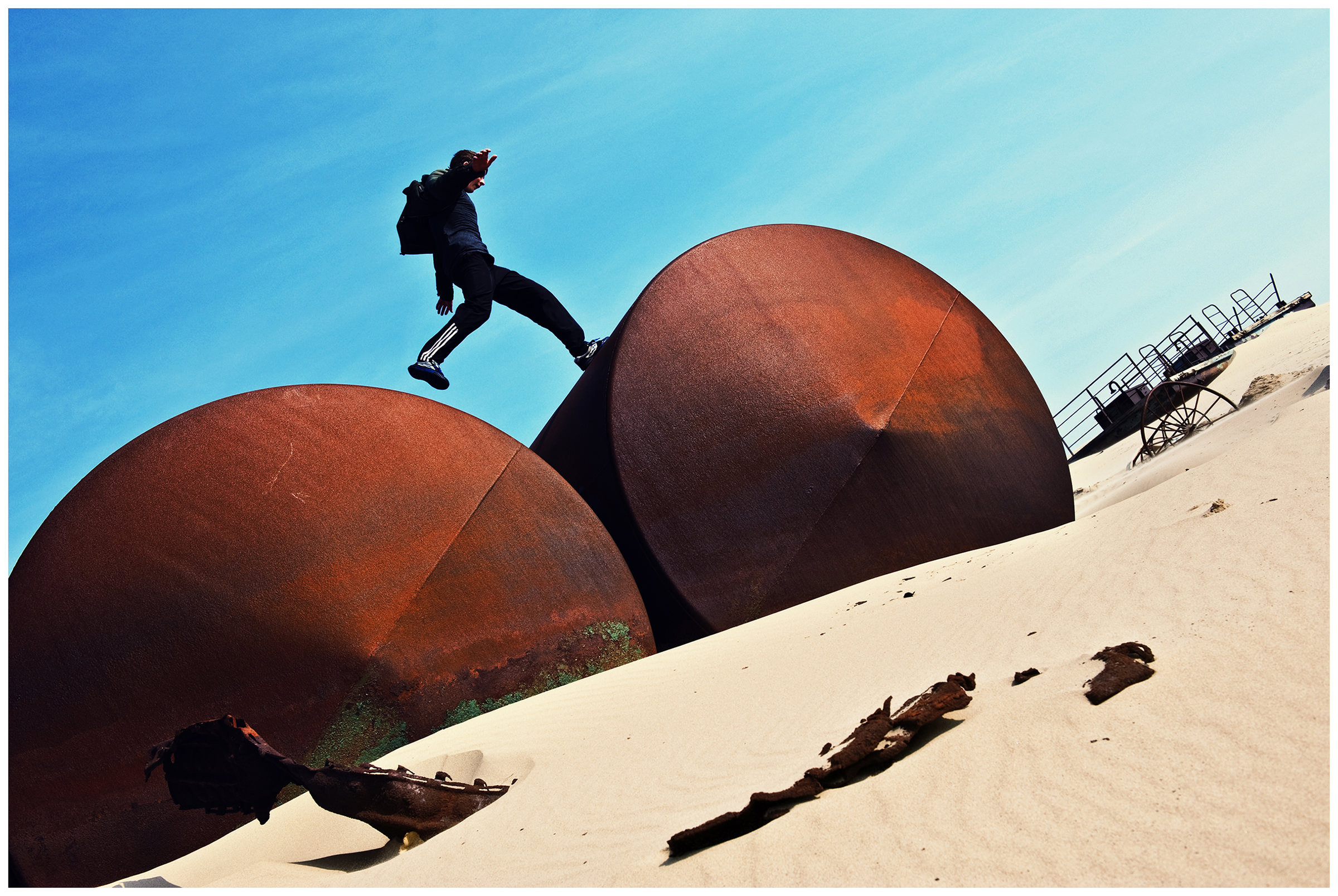 Shoyna village, Russia. A boy jumps between the oil tanks.