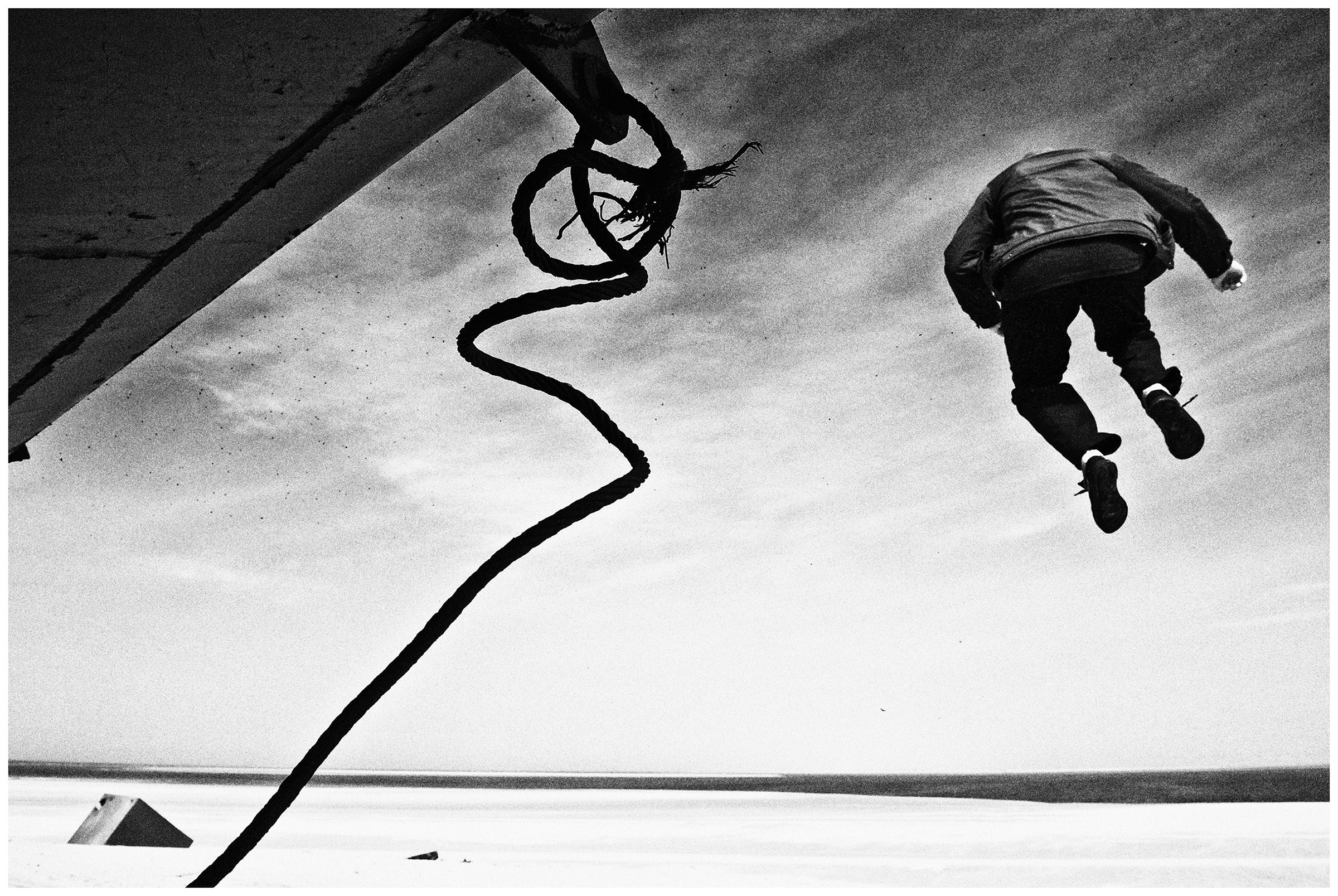 Shoyna village, Russia. A boy jumps down from an oil tank.