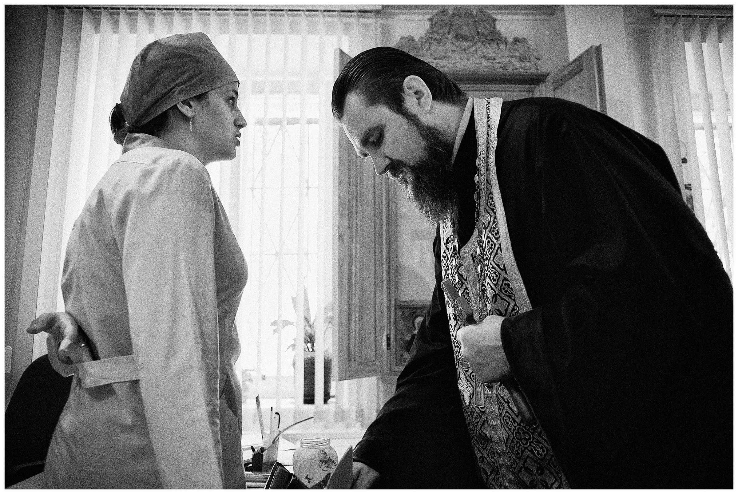 Minsk Hospice, Minsk, Belarus. A nurse speaks with a Russian Orthodox priest.