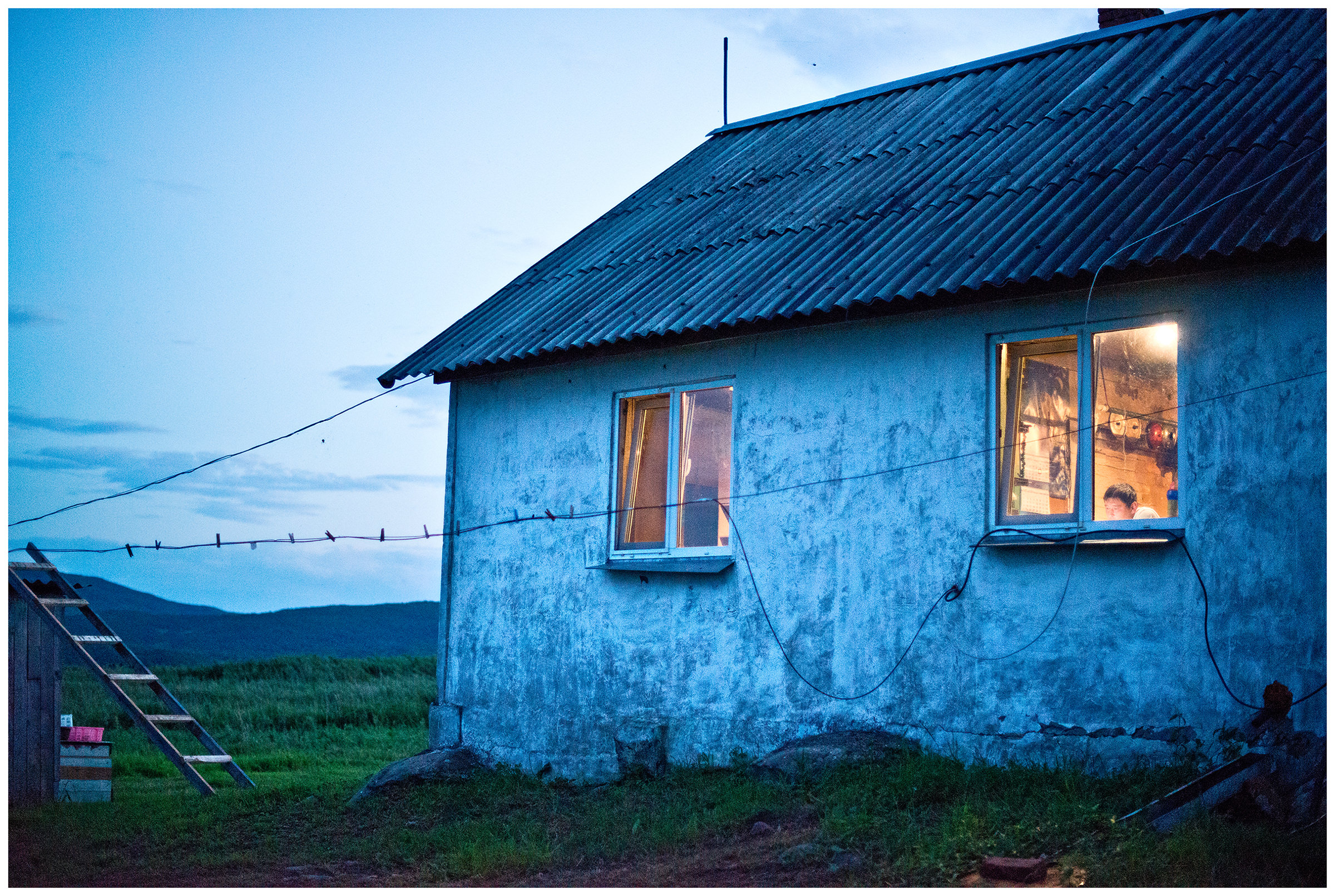 Bay Pemzowaya, Primorye, Russia. A nature conservation inspector works at a border post in the evening.