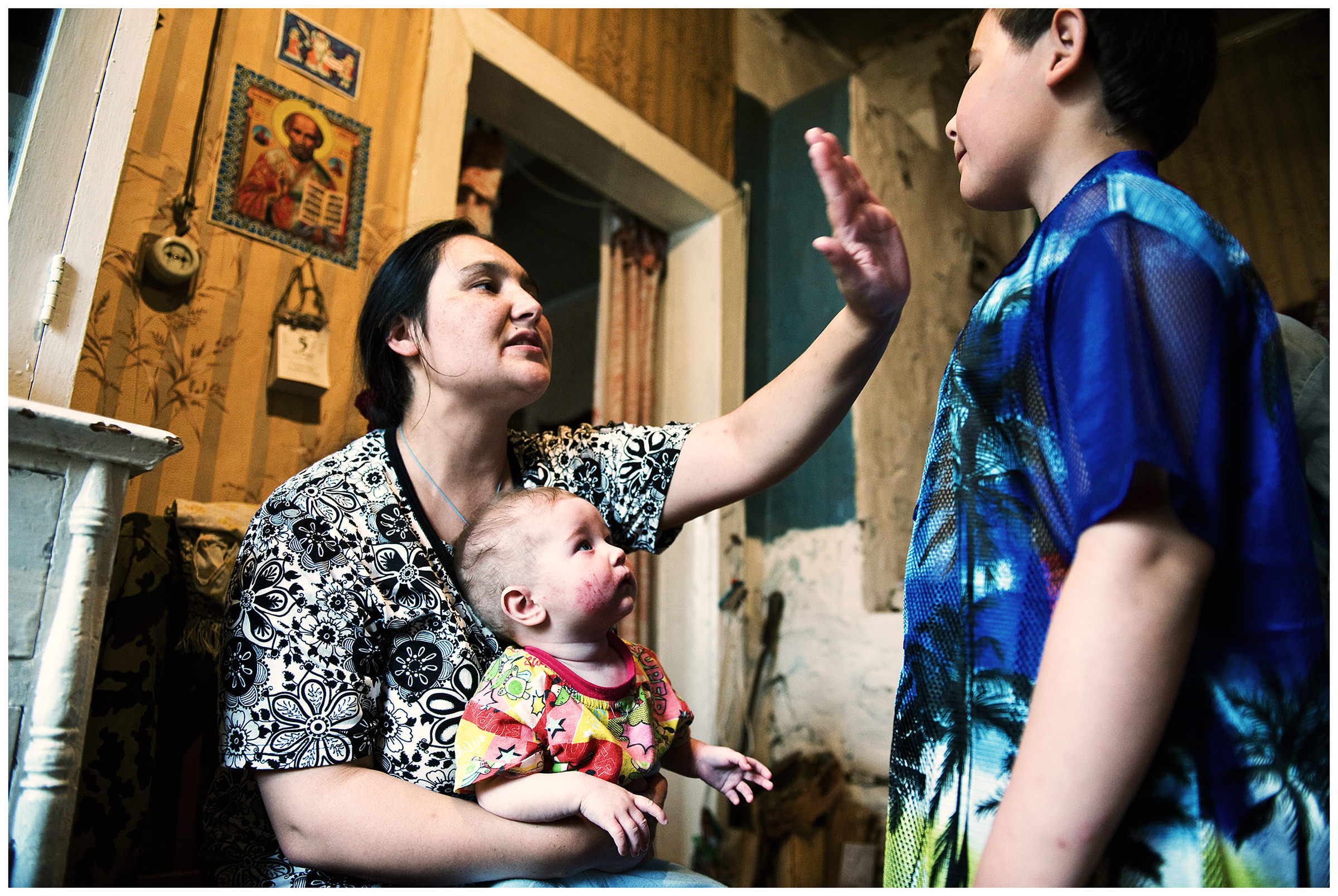 Shoyna village, Russia. A woman talks to his son.