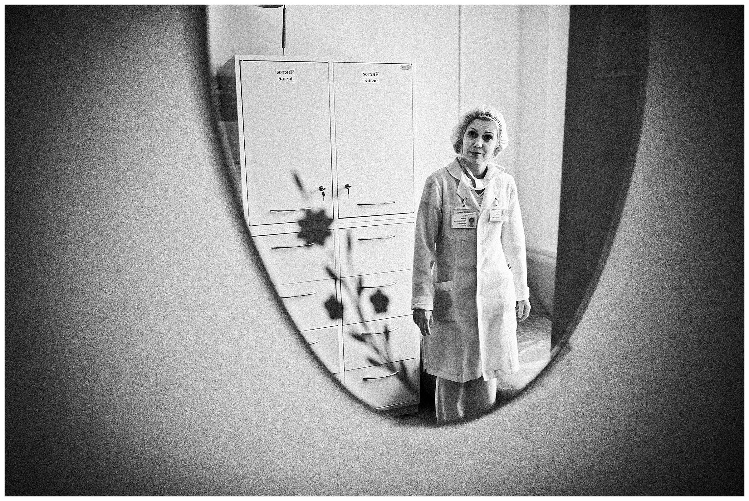 Minsk Hospice, Minsk, Belarus. A nurse is reflected in a mirror in the staff room.