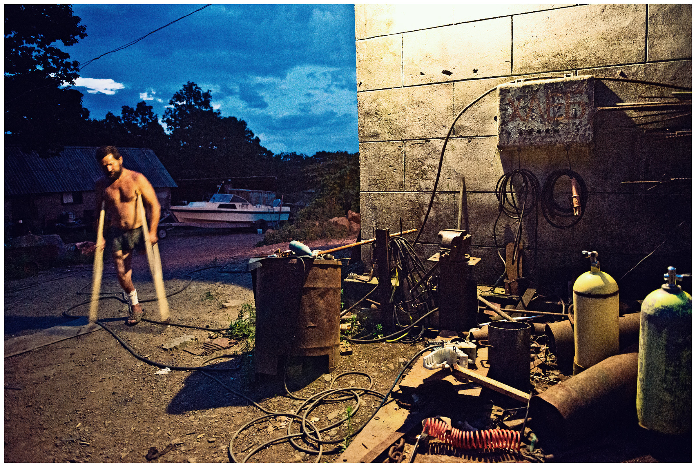 Village Ryasanovka, Primorye, Russia. A man goes home. He lives by filling the poacher's breathing air bottles.