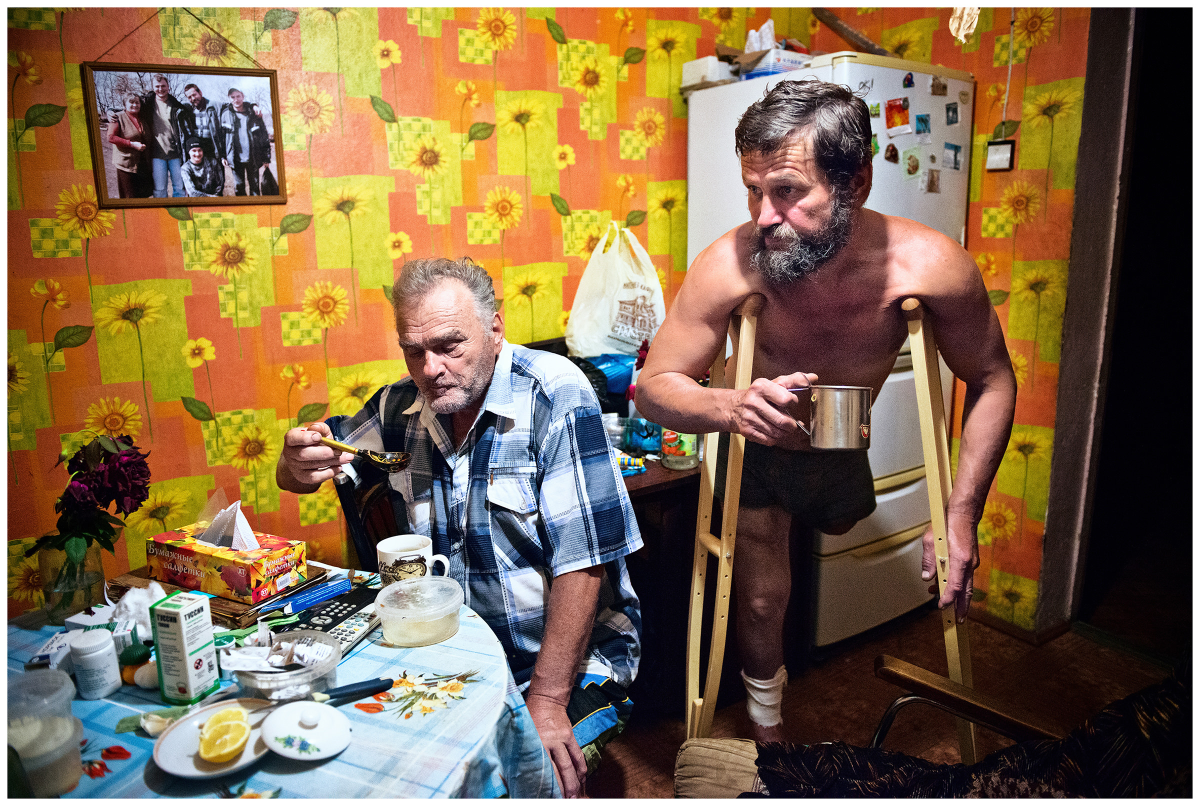Ryazanovka village, Primorye, Russia. Men in a kitchen drink tea and talk.