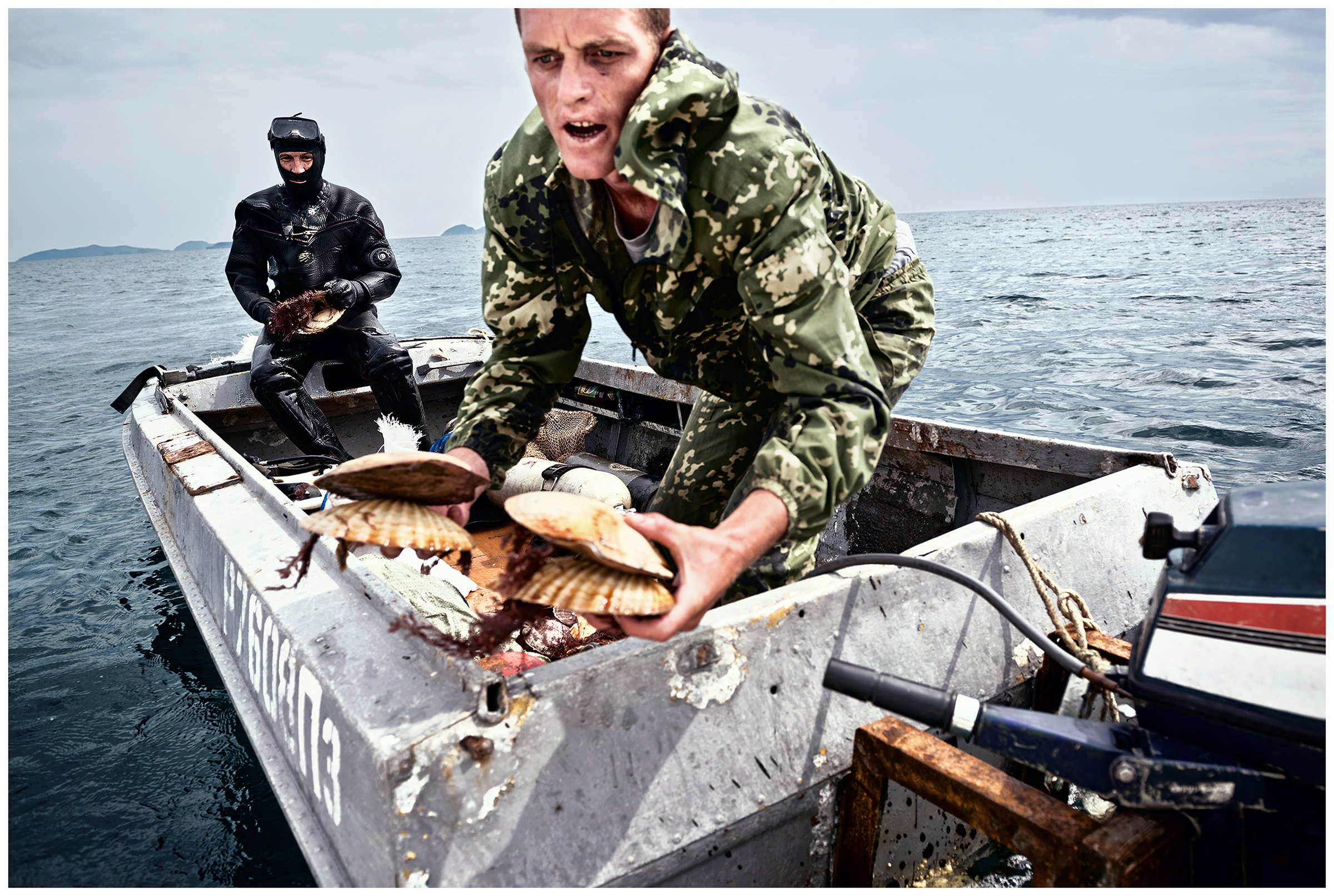 Peter the Great Bay, Sea of Japan, Russia. The poachers store freshly caught scallops from one boat to another.