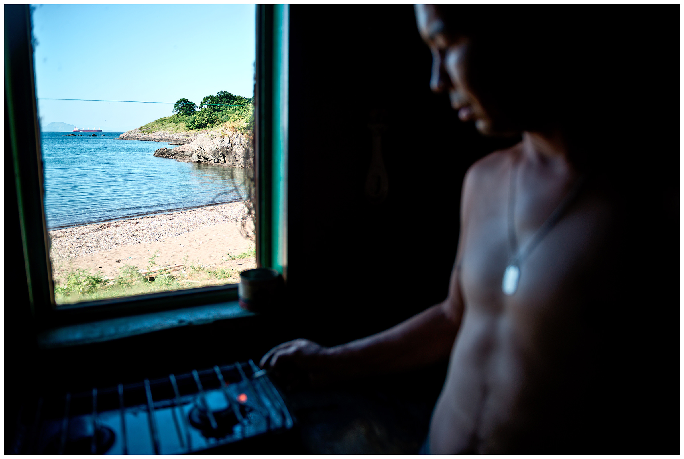 Krabbe Peninsula, Primorye, Russia. On the Krabbe peninsula an inspector guards a private maritime company. A man lights a flame in a gas stove.