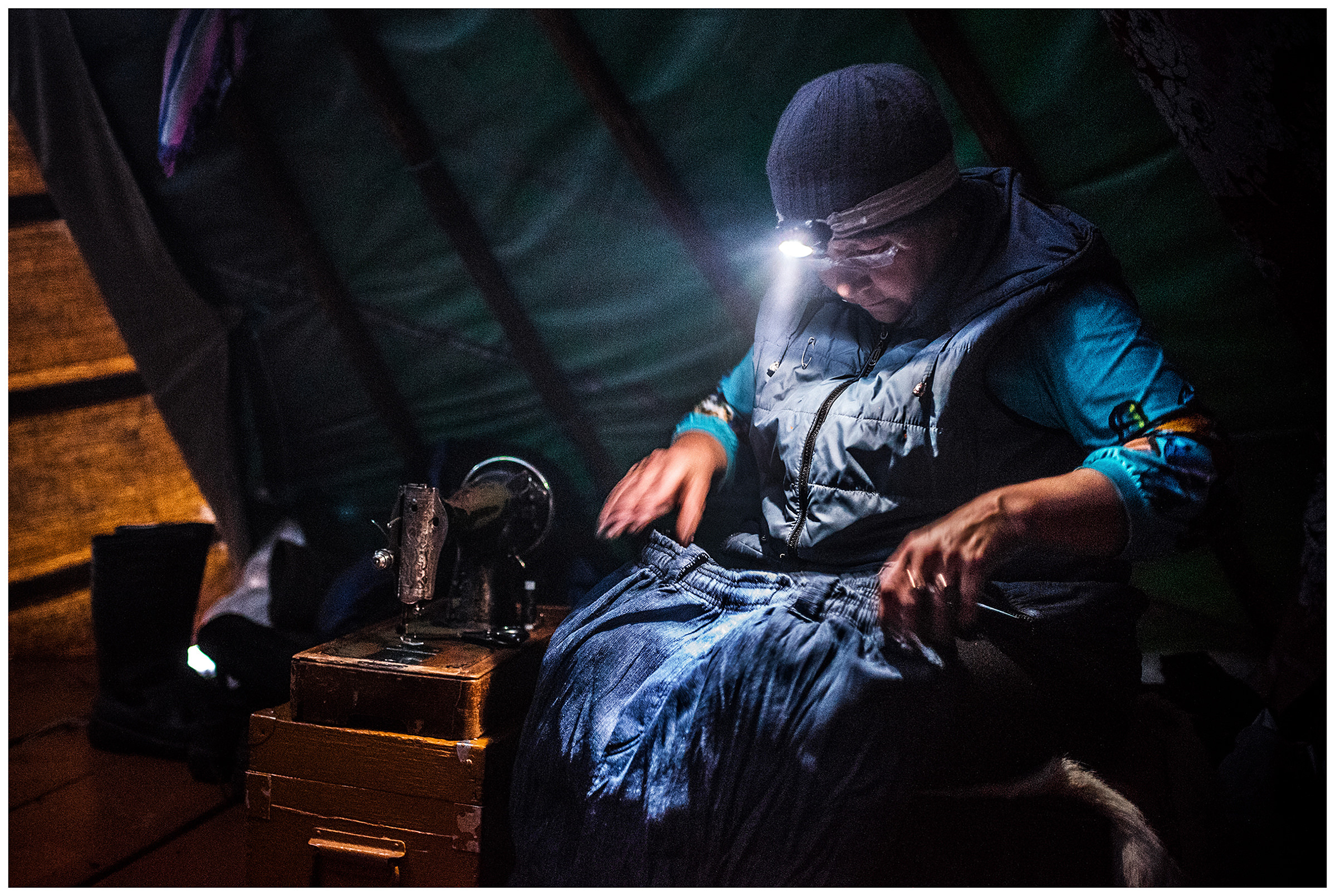 Nenets Autonomous Okrug, Komi Republic, Russia. Komi woman working with her sewing machine in a tent.