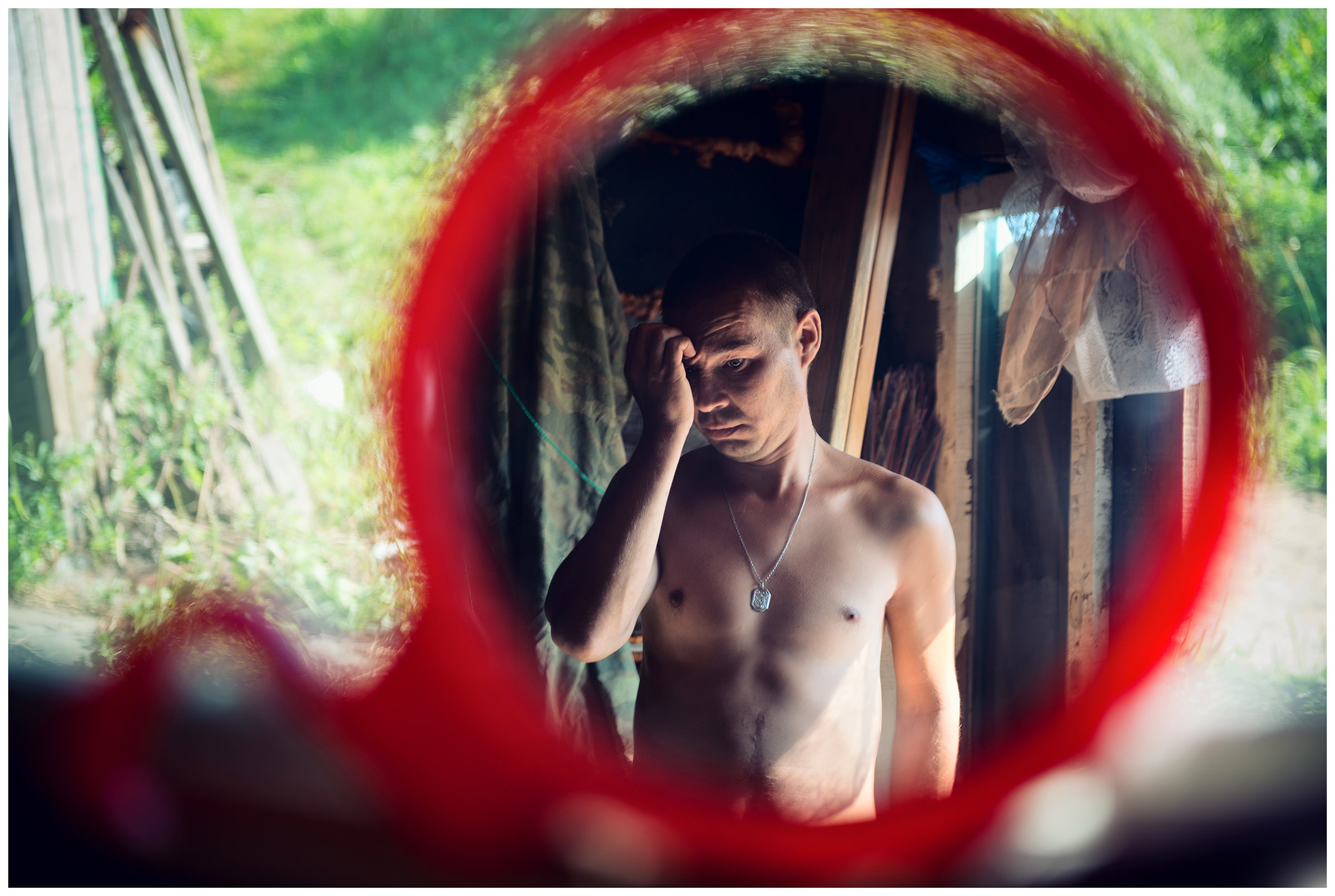 Krabbe Peninsula, Primorye, Russia. On the Krabbe peninsula an inspector guards a private maritime company. A man is reflected in a mirror.