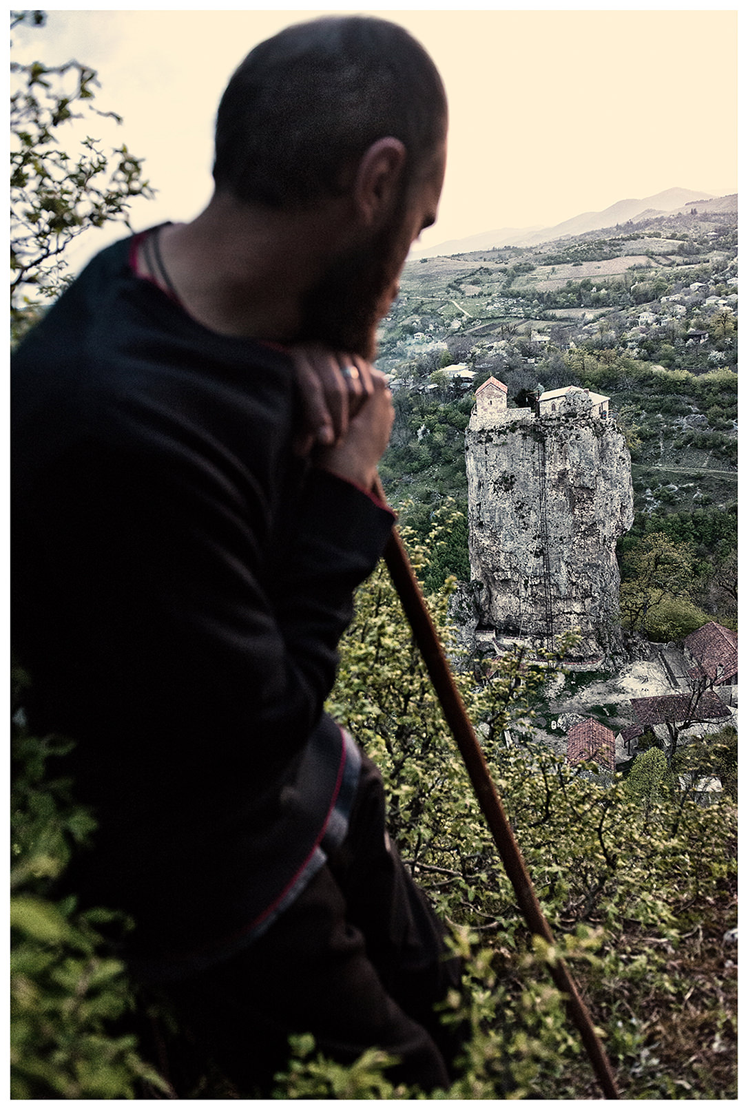Imereti, Georgia. A friend of the Georgian monk Maxime Kavtaradze stands on a rock with a stick in his hand.