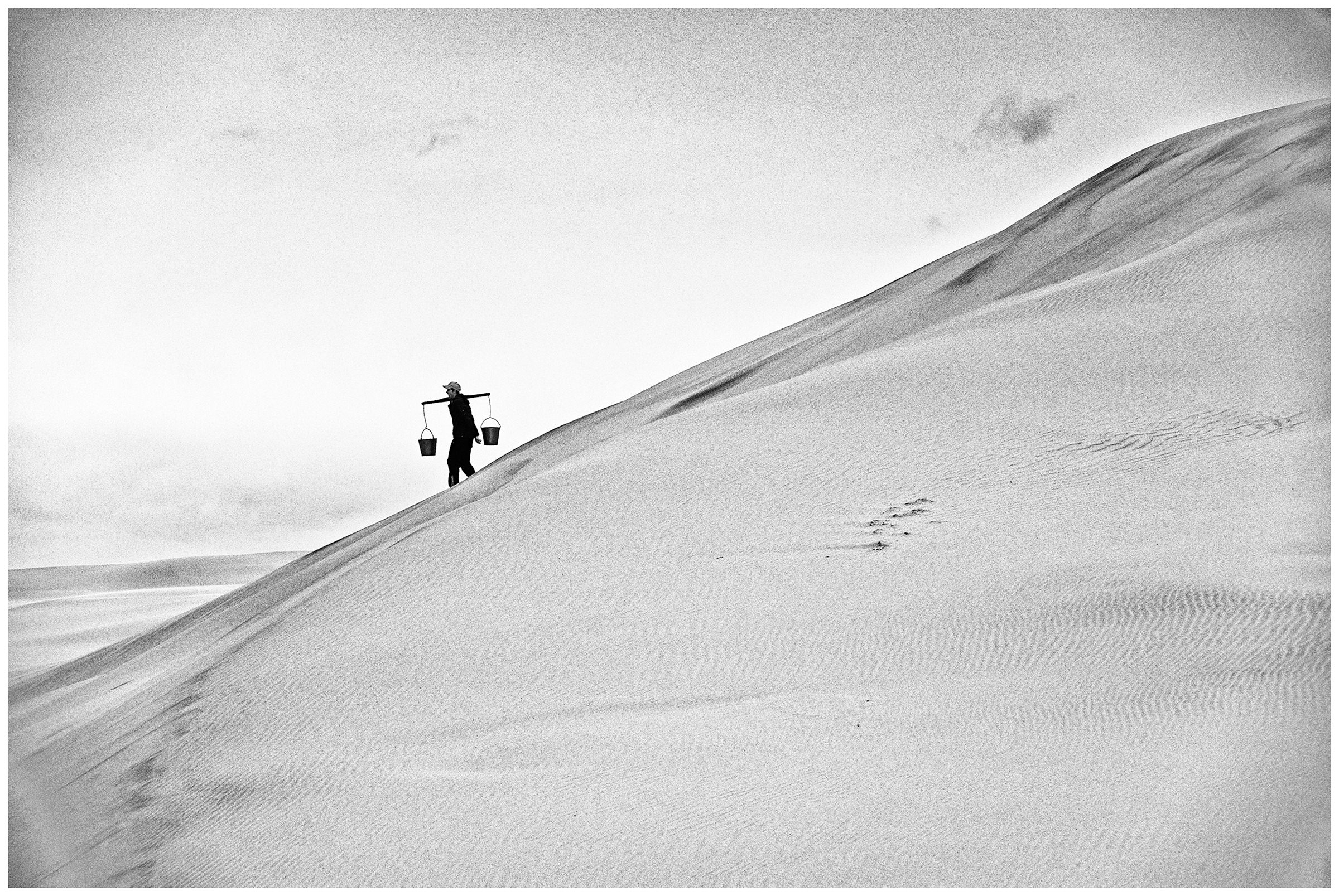 Shoyna village, Russia. A boy fetches water with two buckets of water.
