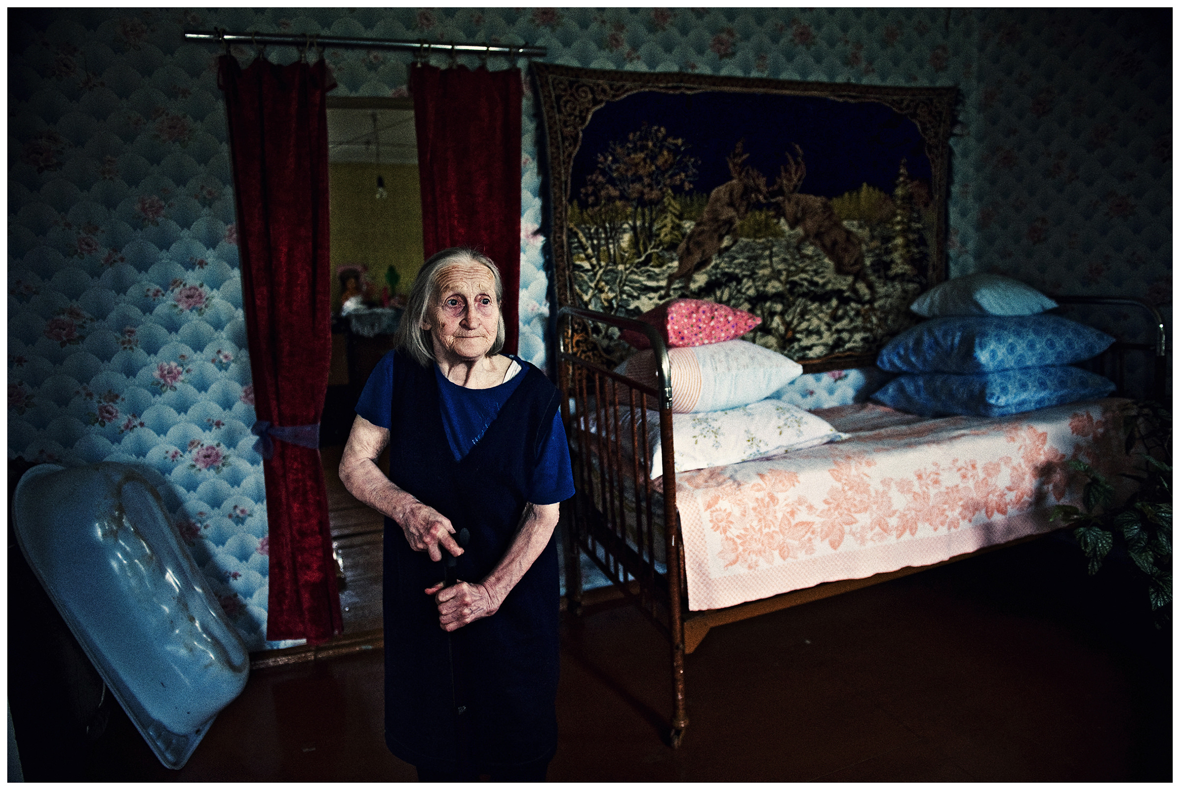 Shoyna village, Russia. An old woman is standing in her house.