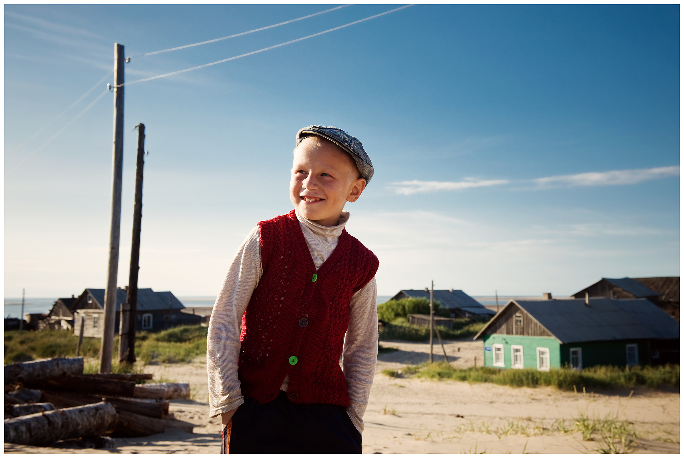 Shoyna village, Russia. A boy in a red vest stands in the middle of the village.