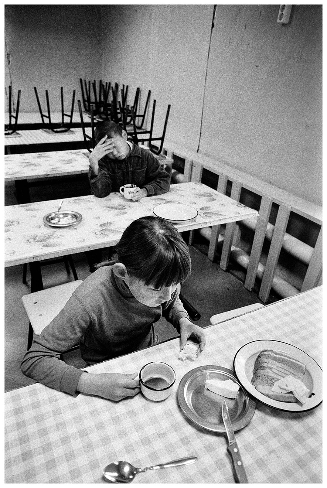 Shoyna village, Russia. A boy and a girl in boarding school drink tea.