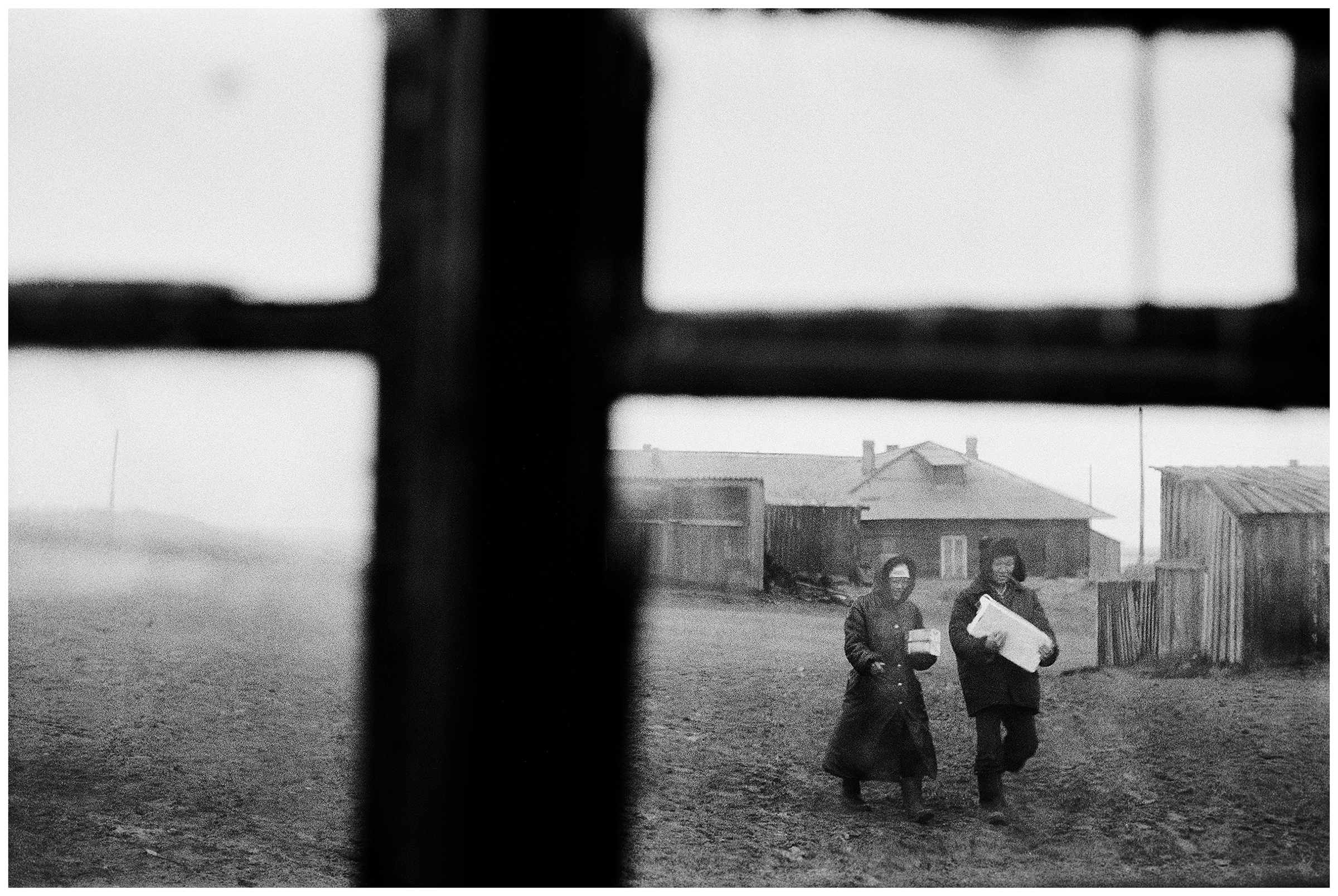Shoyna village, Russia. A man and a woman can be seen through a window.