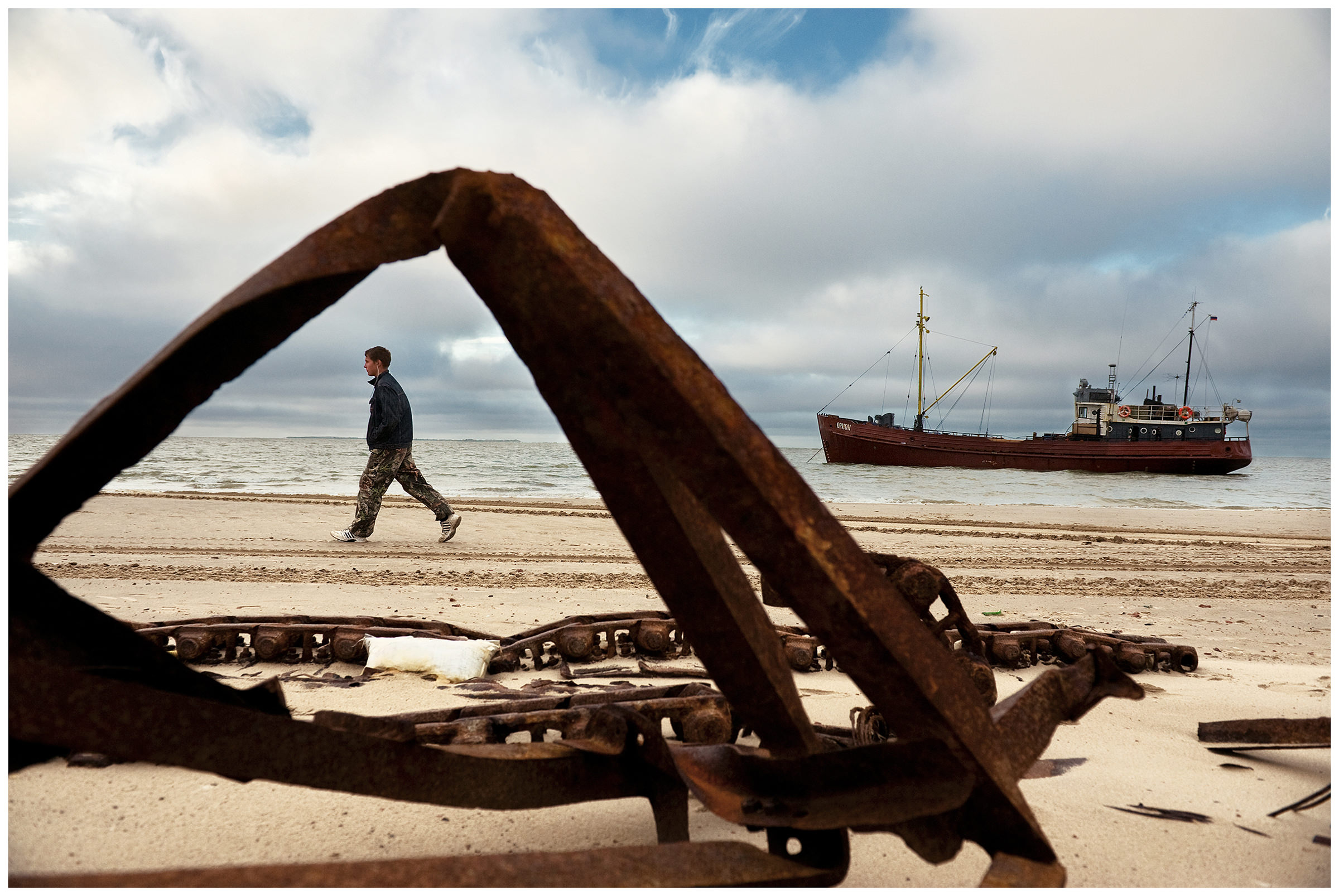 Shoyna village, Russia. A young man walks on the coast.